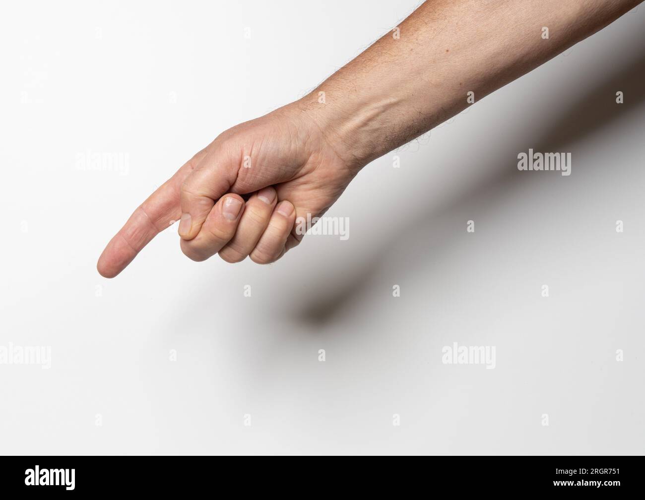 una mano maschile che punta con un dito su uno sfondo bianco Foto Stock