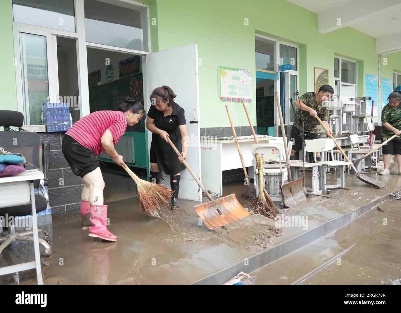 Laishui, provincia cinese di Hebei. 11 agosto 2023. Gli insegnanti puliscono le aule in una scuola nella città di Qizhongkou della contea di Laishui, nella provincia di Hebei nella Cina settentrionale, 11 agosto 2023. Alcune scuole, situate nelle zone montagnose della contea di Laishui, hanno recentemente svolto lavori di recupero post-alluvione. Il personale competente ha studiato accuratamente le scuole per potenziali rischi per la sicurezza, pulito i campus e ha effettuato la disinfezione per la prevenzione e il controllo delle epidemie. Crediti: Wang Kun/Xinhua/Alamy Live News Foto Stock