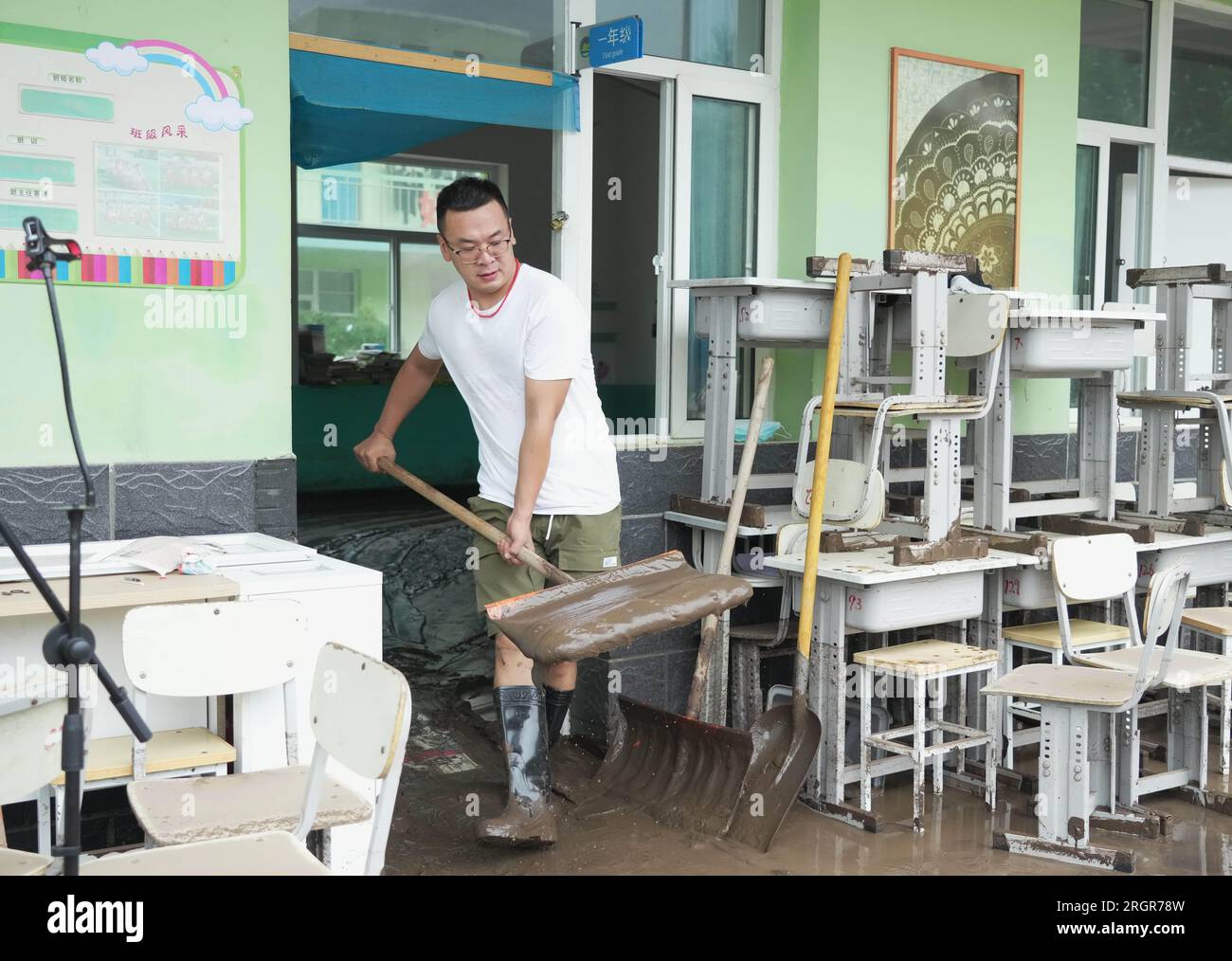 Laishui, provincia cinese di Hebei. 11 agosto 2023. Un insegnante pulisce i fanghi in una scuola nella città di Qizhongkou della contea di Laishui, nella provincia di Hebei nella Cina settentrionale, 11 agosto 2023. Alcune scuole, situate nelle zone montagnose della contea di Laishui, hanno recentemente svolto lavori di recupero post-alluvione. Il personale competente ha studiato accuratamente le scuole per potenziali rischi per la sicurezza, pulito i campus e ha effettuato la disinfezione per la prevenzione e il controllo delle epidemie. Crediti: Wang Kun/Xinhua/Alamy Live News Foto Stock