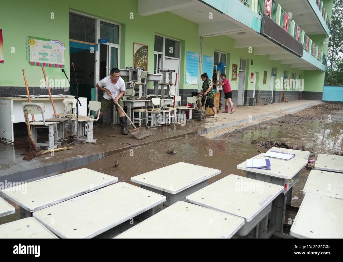 Laishui, provincia cinese di Hebei. 11 agosto 2023. Gli insegnanti ripuliscono i fanghi in una scuola nella città di Qizhongkou della contea di Laishui, nella provincia di Hebei nella Cina settentrionale, 11 agosto 2023. Alcune scuole, situate nelle zone montagnose della contea di Laishui, hanno recentemente svolto lavori di recupero post-alluvione. Il personale competente ha studiato accuratamente le scuole per potenziali rischi per la sicurezza, pulito i campus e ha effettuato la disinfezione per la prevenzione e il controllo delle epidemie. Crediti: Wang Kun/Xinhua/Alamy Live News Foto Stock