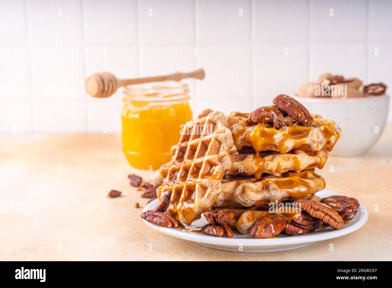Waffle belgi allo sciroppo d'acero di pecan con salsa al caramello, ricetta di cottura fatta in casa idea di torta d'autunno Foto Stock