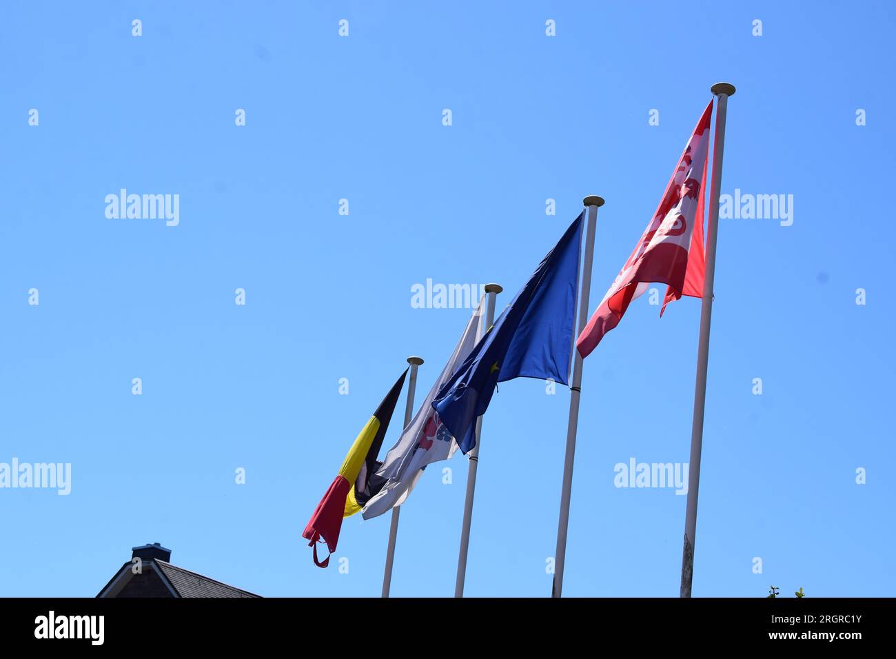 sventolando bandiere davanti al cielo blu Foto Stock