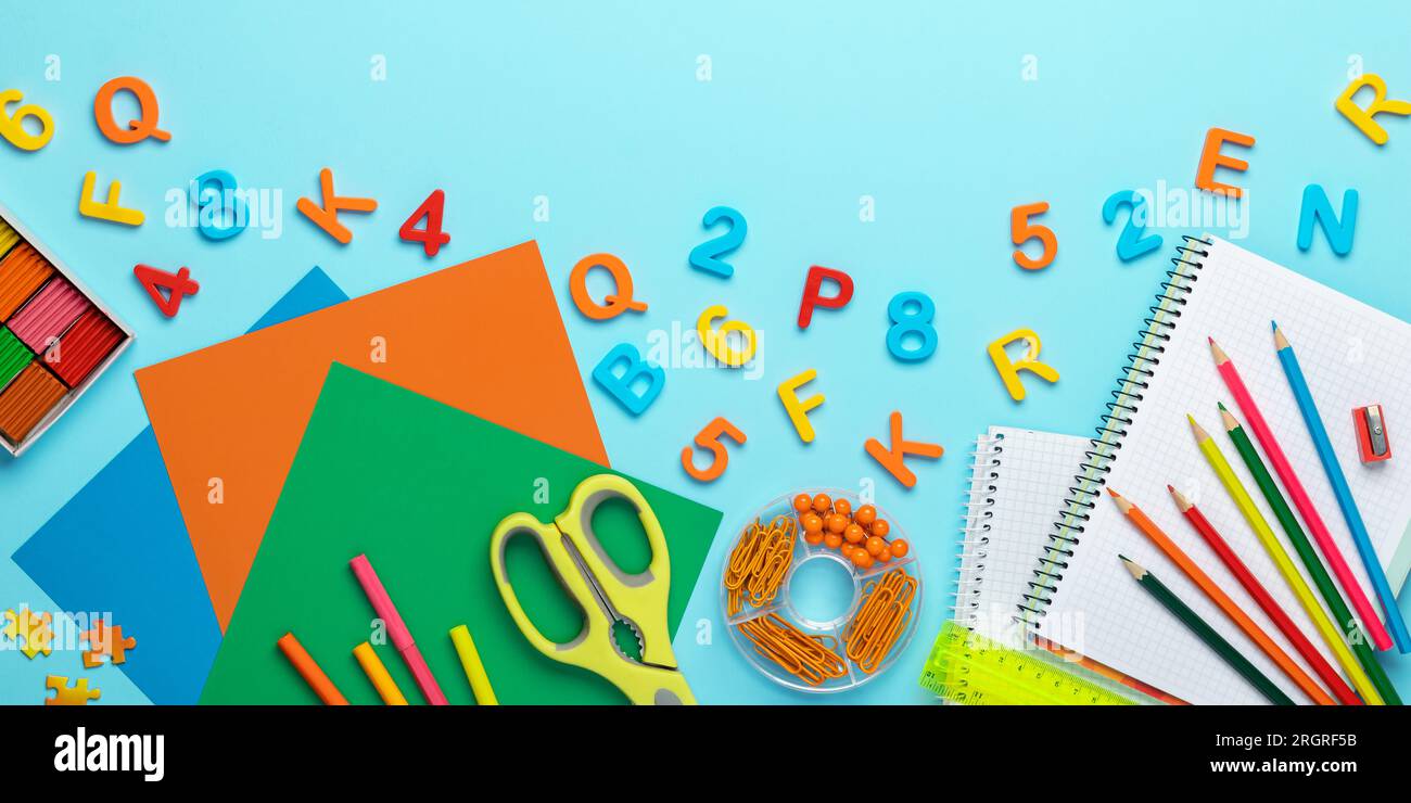 Ritorno a scuola. Plasticina, forbici, carta colorata per artigianato, matite, taccuino, righello, numeri e lettere in plastica. Cancelleria colorata Foto Stock