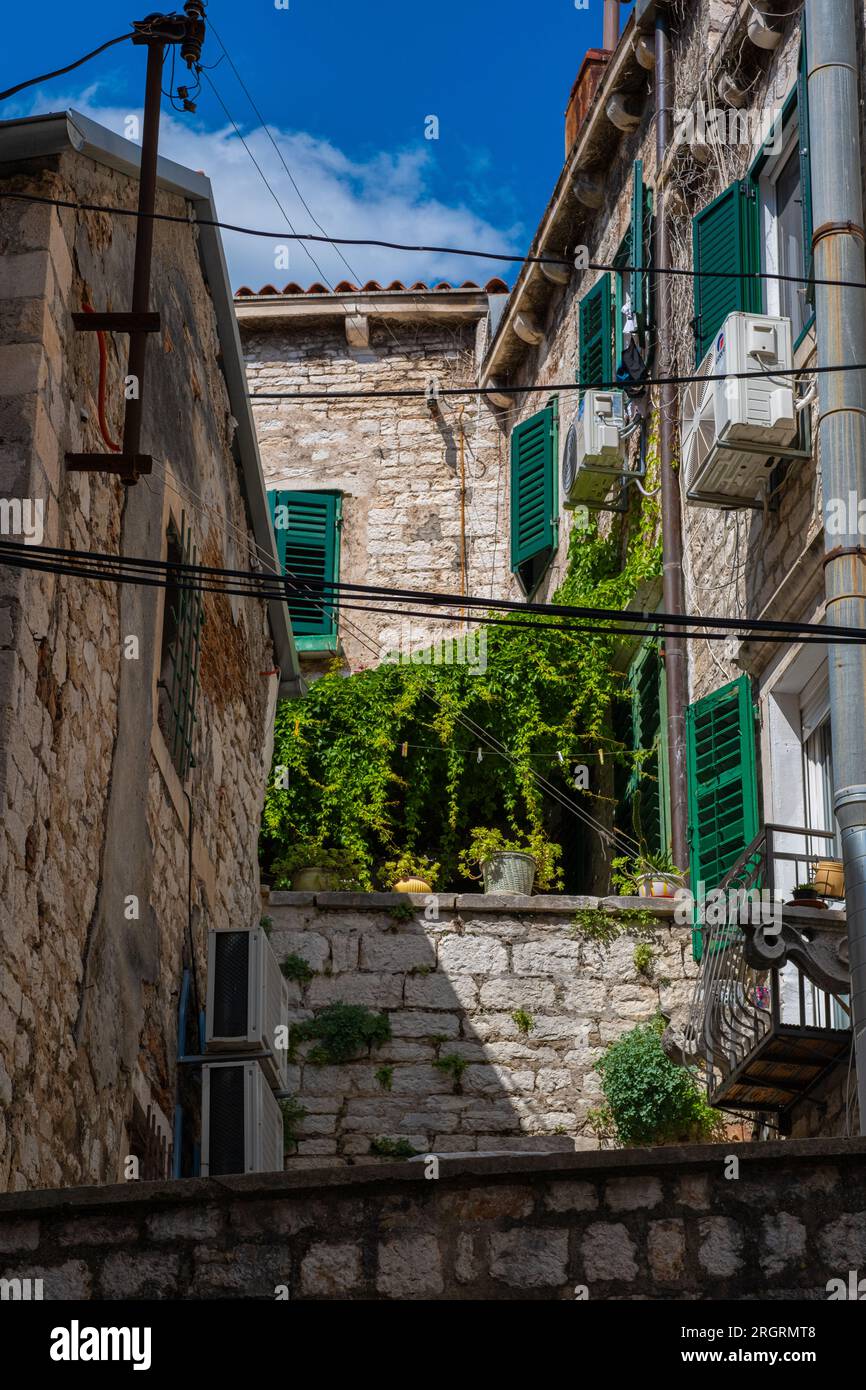 La città vecchia di Sibenik in Croazia. Strade strette, edifici d'epoca e finestre di vecchie case. Sito patrimonio mondiale dell'UNESCO, città di marmo di Sibenik Foto Stock