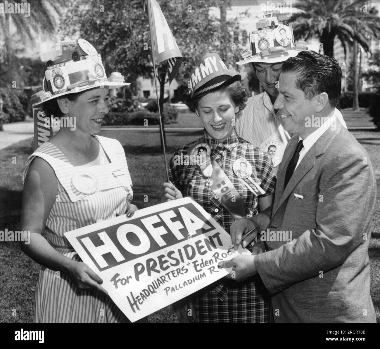 Miami Beach, Florida: 1 ottobre 1957, il vice presidente della Teamsters union Jimmy Hoffa autografa un cartello per lui per un gruppo di donne che lottano per la sua candidatura a presidente dei Teamsters. Foto Stock