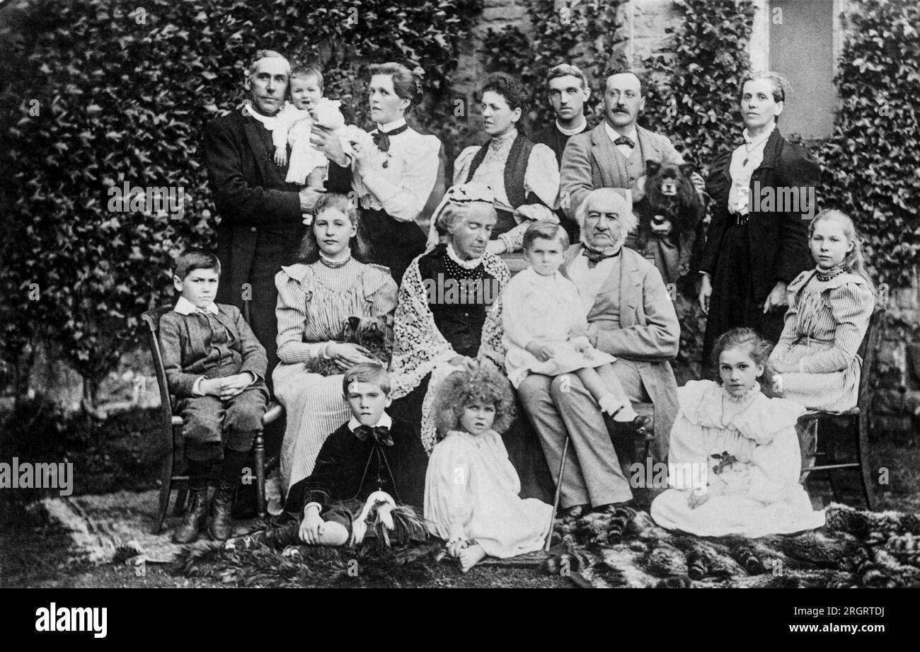 Londra, Inghilterra: c. 1894 Un ritratto del primo ministro e statista britannico, William E. Gladstone seduto fuori con la sua famiglia. Foto Stock