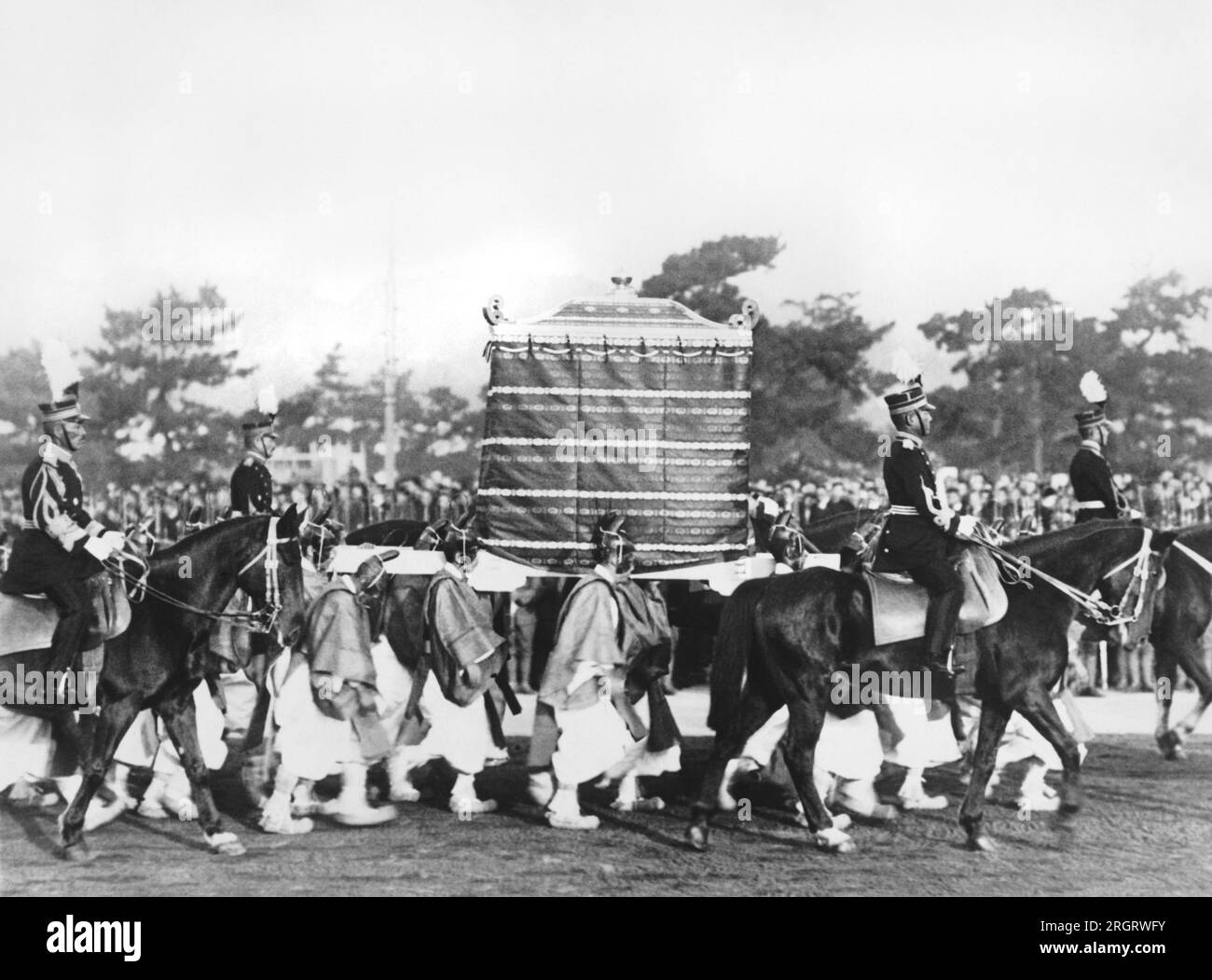 Kyoto, Giappone: Novembre 1928 la Kashikodokoro, Arca del Sacro Specchio, dedicata all'anima della Dea del Sole, passando per le cerimonie di incoronazione dell'imperatore Hirohito. I 'Yase Boys', portatori dell'Arca da tempo immemorabile, lo portano sulle loro spalle. Foto Stock