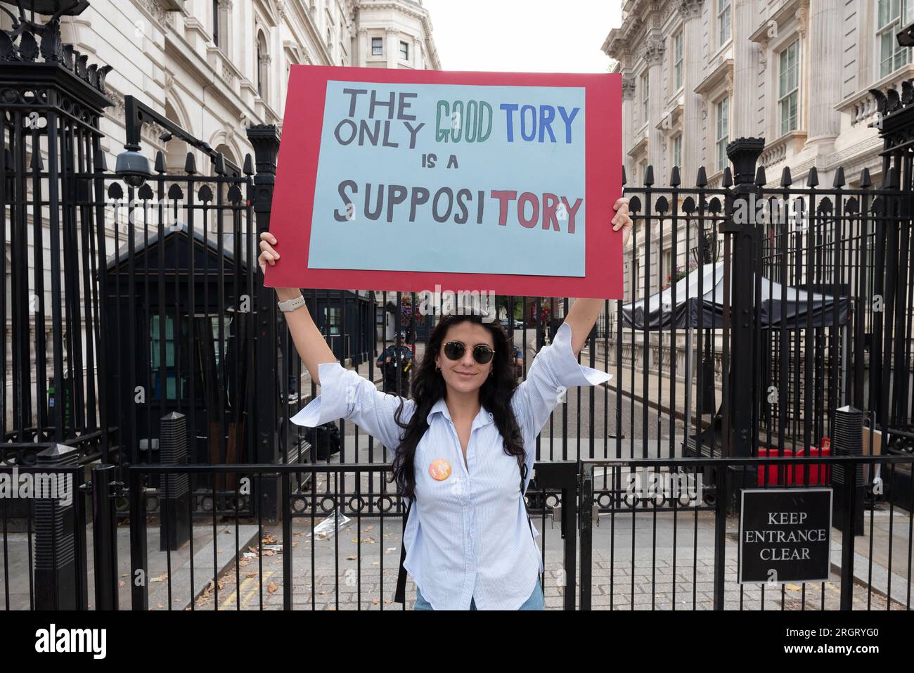 Londra, Regno Unito. 11 agosto 2023. Un medico posa con un cartello fuori Downing Street come medici in formazione che lavorano per l'NHS in Inghilterra organizzano un raduno "Pay Restoration" a Whitehall il primo giorno di uno sciopero di quattro giorni in cerca di una paga equa. Crediti: Ron Fassbender/Alamy Live News Foto Stock