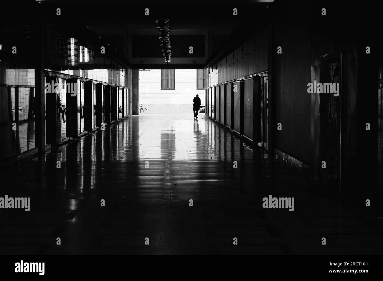 sagome di un uomo in sottopassaggio nel centro storico di milano - fotografia di strada in bianco e nero Foto Stock