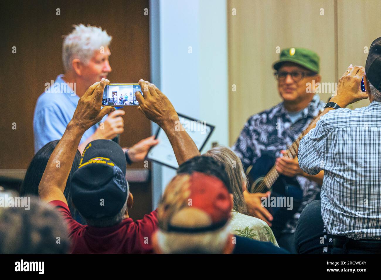 Un'immagine sincera di un ospite che cattura un momento speciale con il suo telefono al Guitars for Vets Graduation presso la Loma Linda va Clinic nell'agosto 2023 Foto Stock