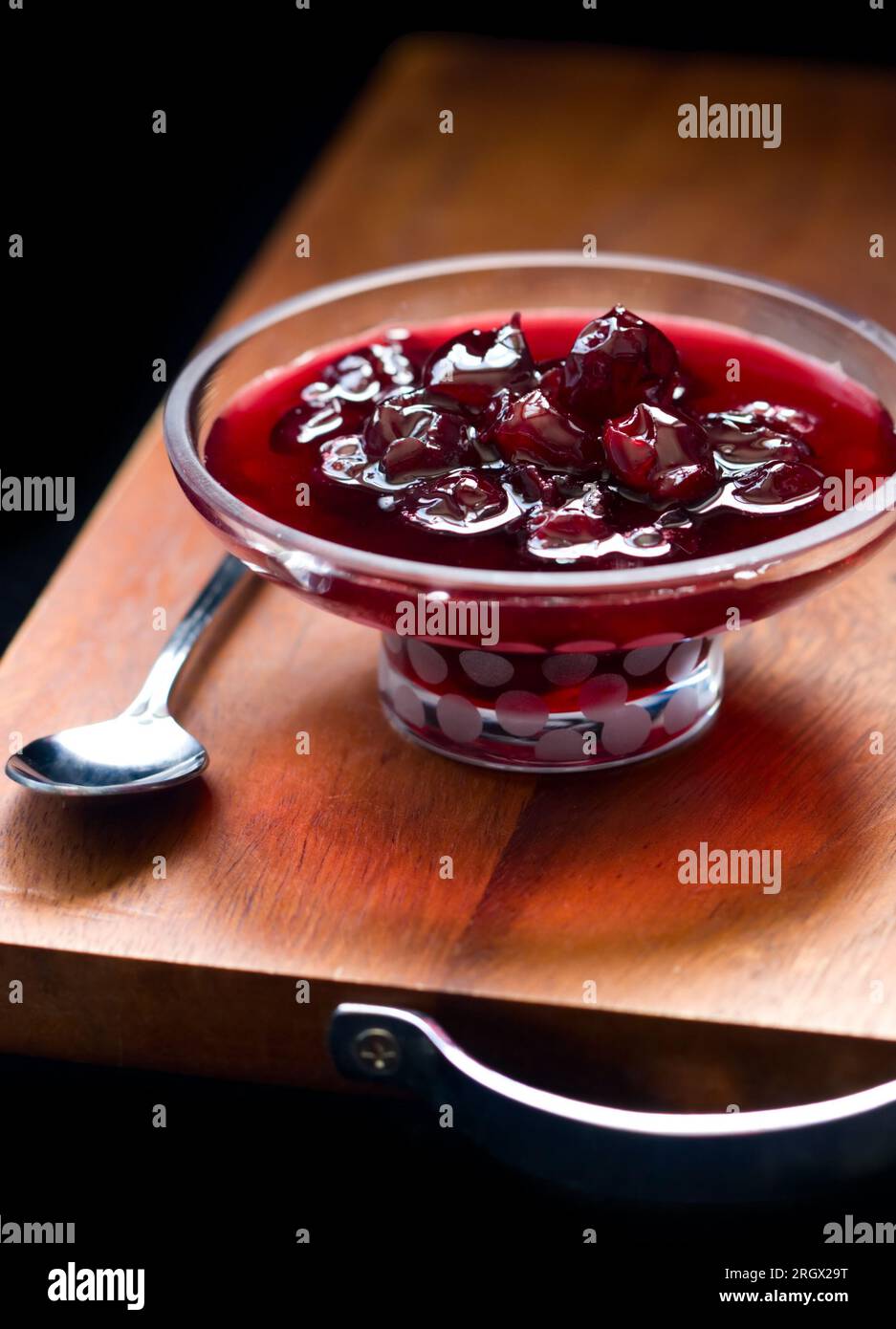 marmellata di ciliegie fatta in casa in una piccola ciotola con piedistallo in vetro Foto Stock