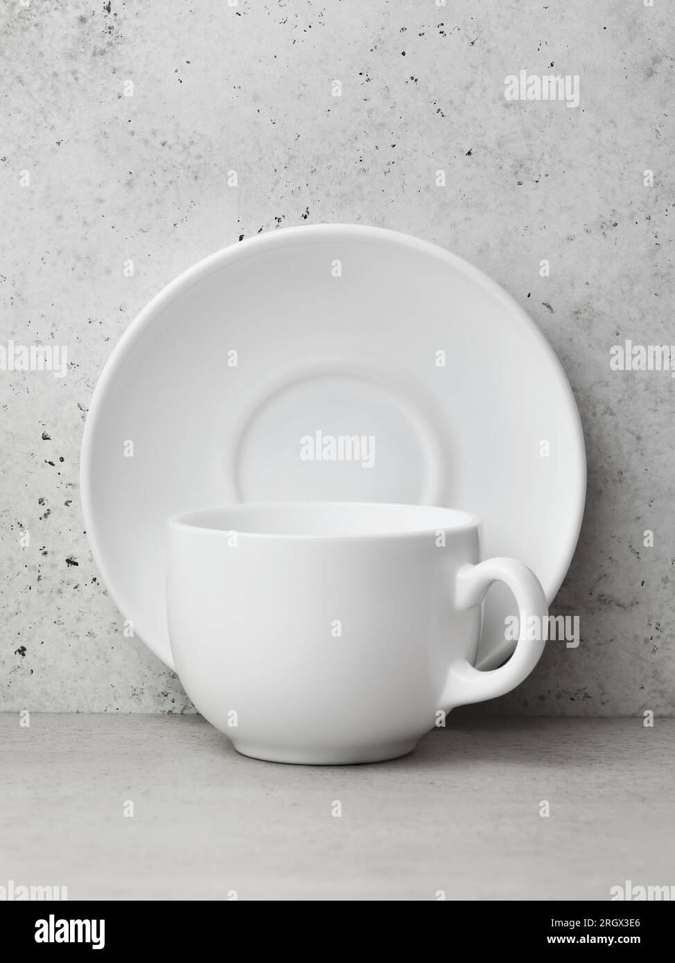 Un piattino in ceramica bianca e una tazza per tè o caffè sul tavolo Foto Stock