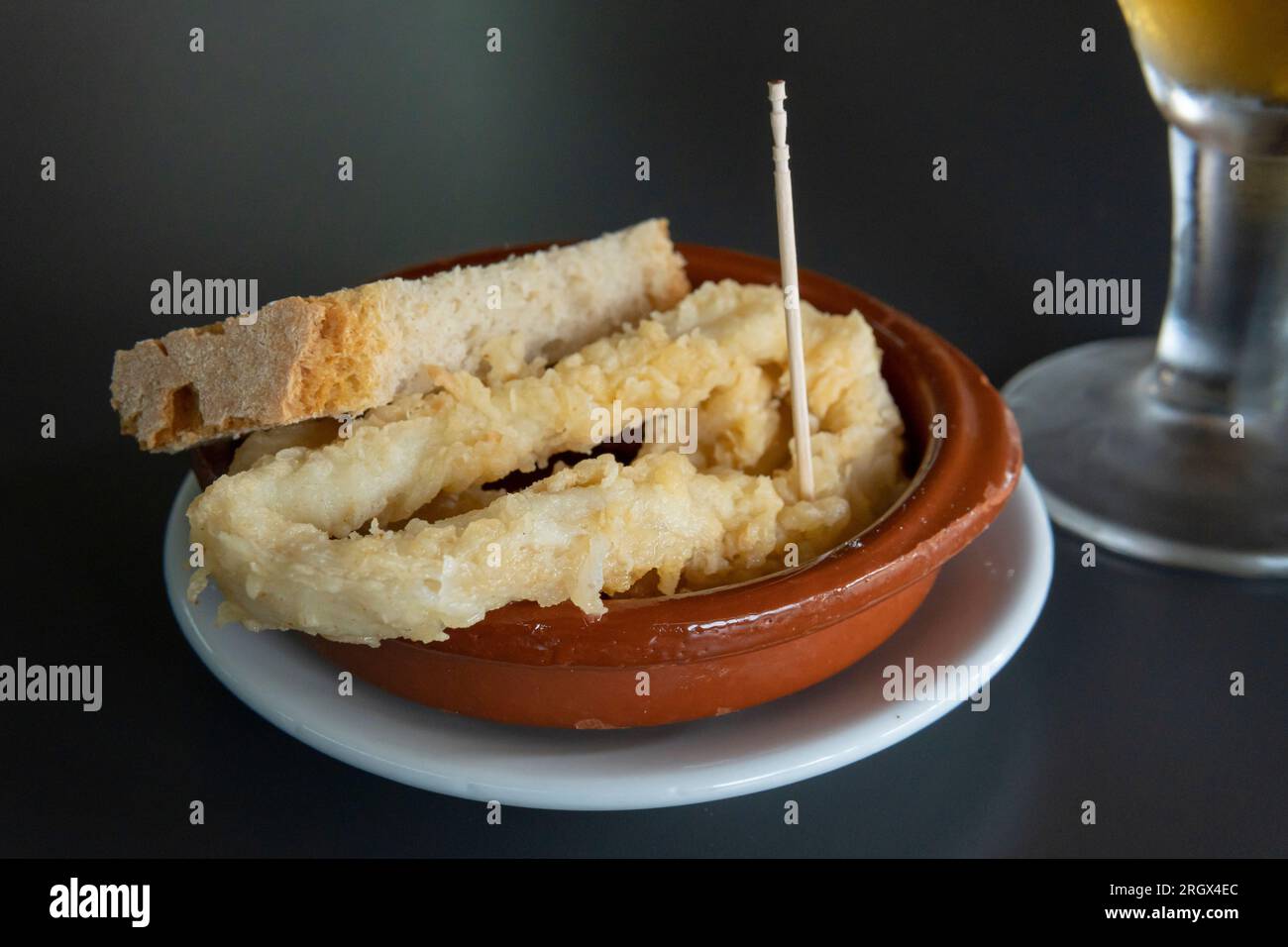 Primo piano di una tapa di calamari in pastella con una birra in una caffetteria. Isola di Maiorca, Spagna Foto Stock