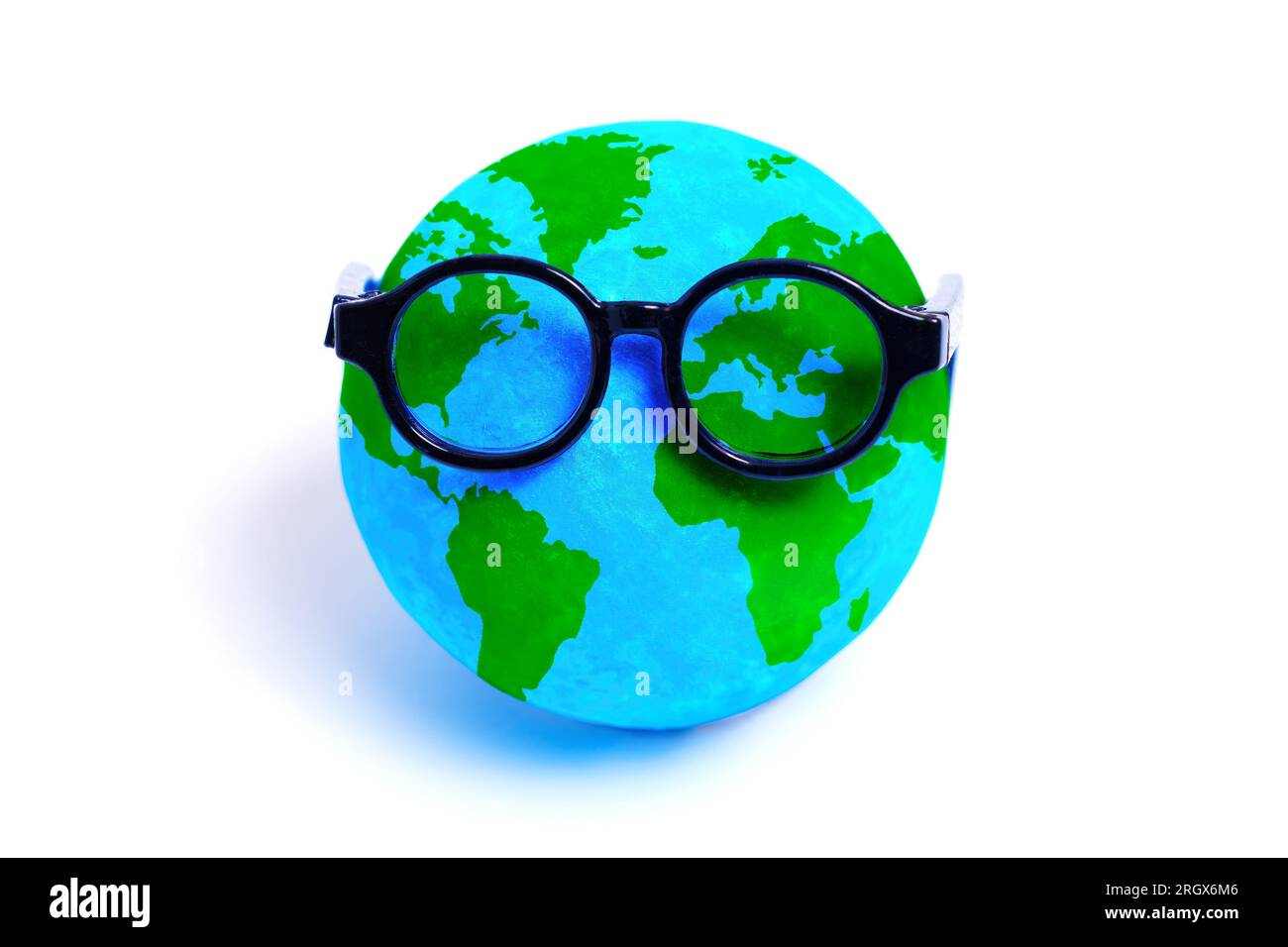 Primo piano di un piccolo globo che indossa occhiali isolati su bianco. Ricerca della conoscenza, acquisizione della conoscenza e concetto di consapevolezza globale. Foto Stock