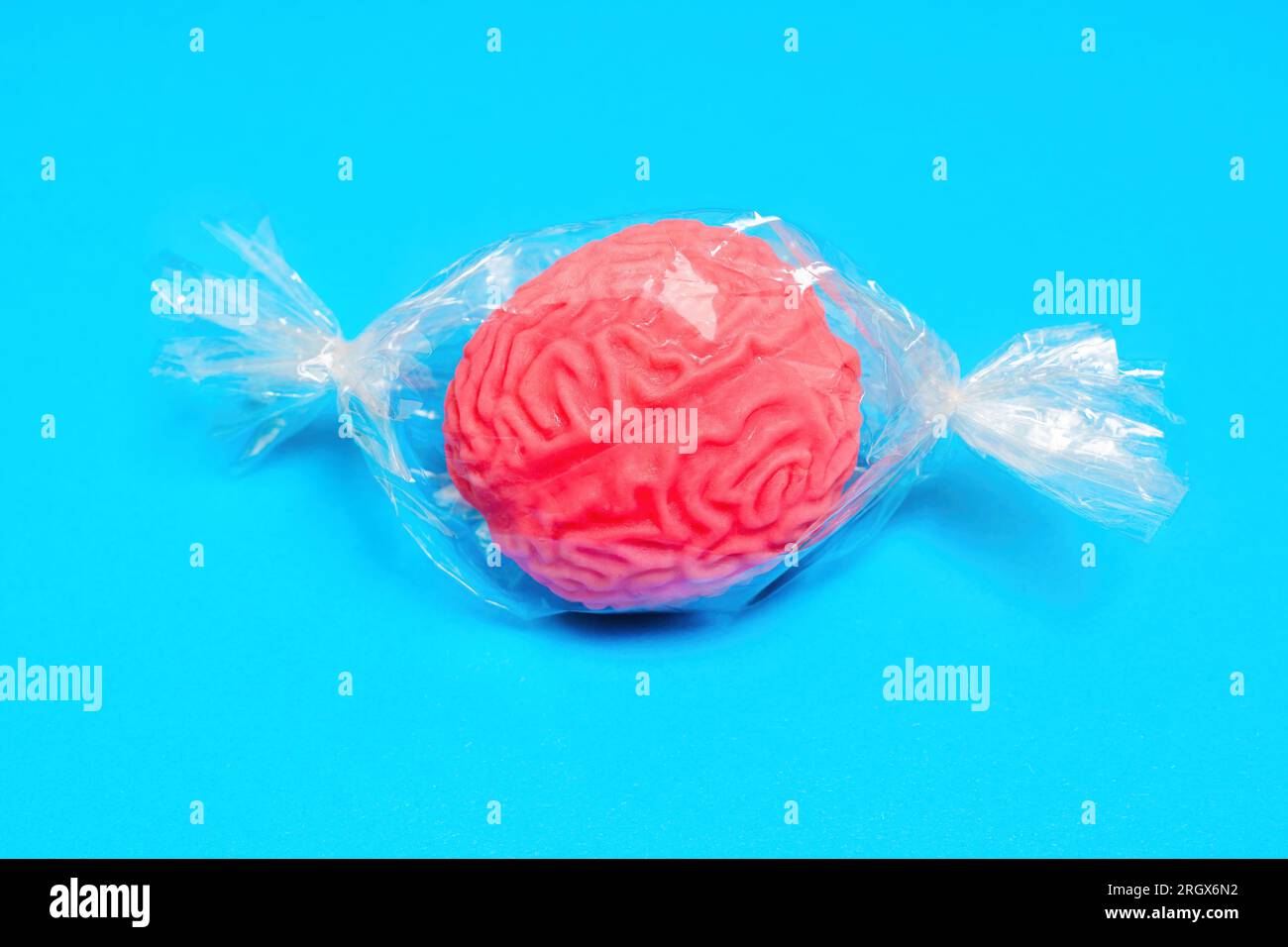 Modello di cervello umano in miniatura avvolto in plastica, simile a una caramella. Sviluppare il concetto di fragilità cerebrale. Foto Stock