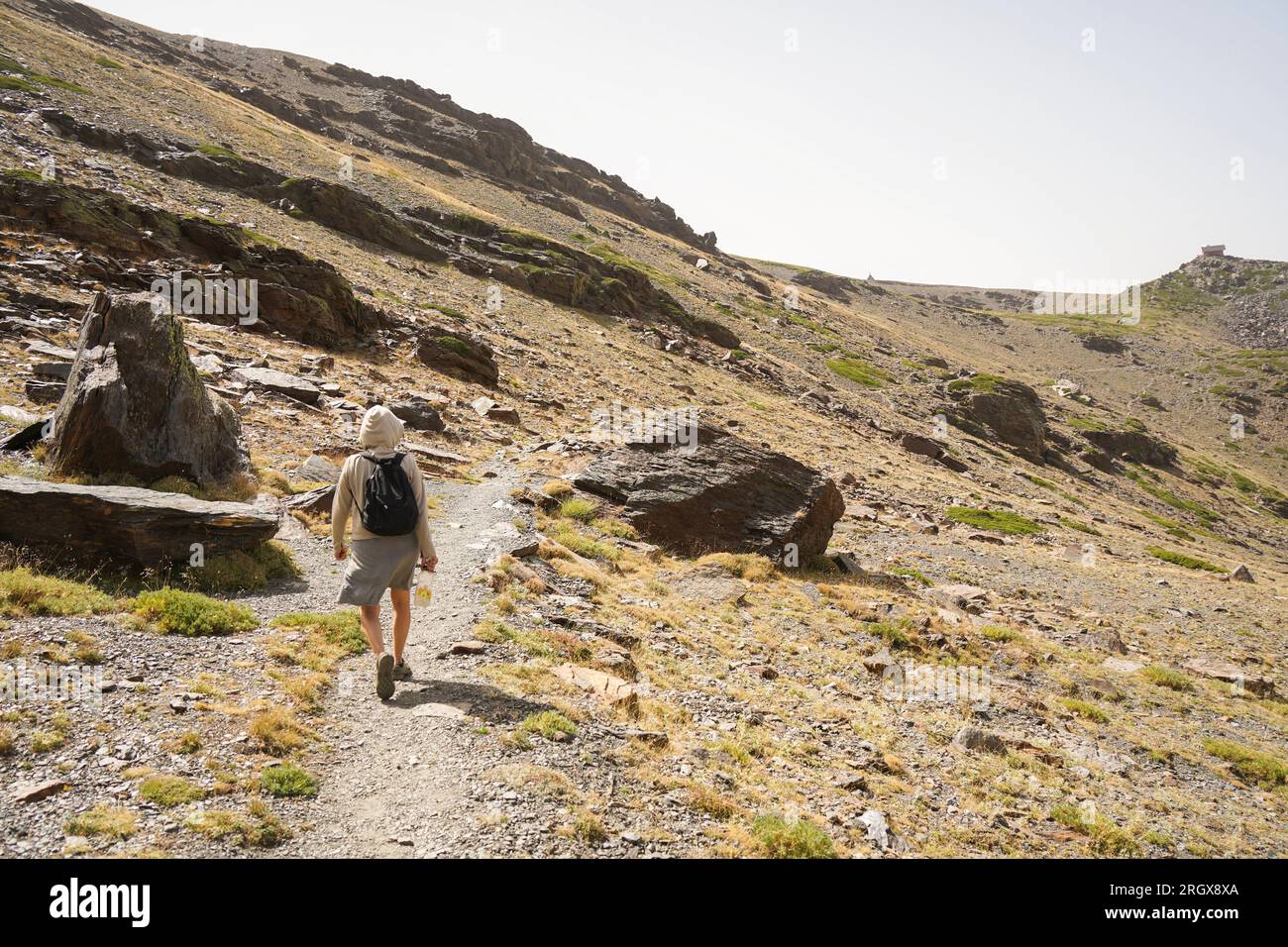 Escursionista che cammina da sola in montagna, Sierra Nevada, nella stagione estiva. Granada, Andalusia, Spagna. Foto Stock