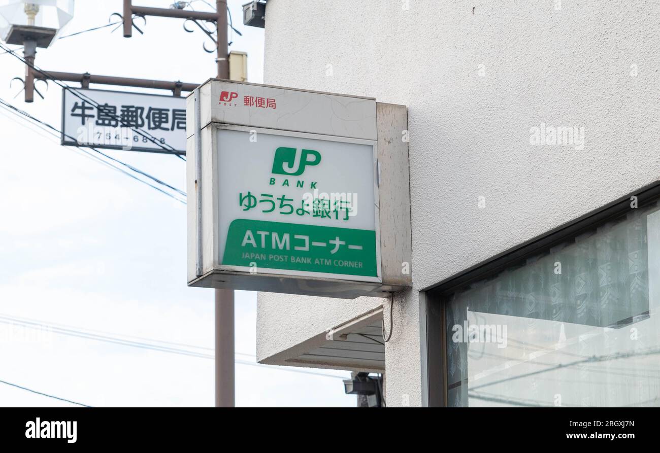 Una piccola filiale locale dell'ufficio postale giapponese con un cartello postale JP appeso sopra l'entrata anteriore. Foto Stock