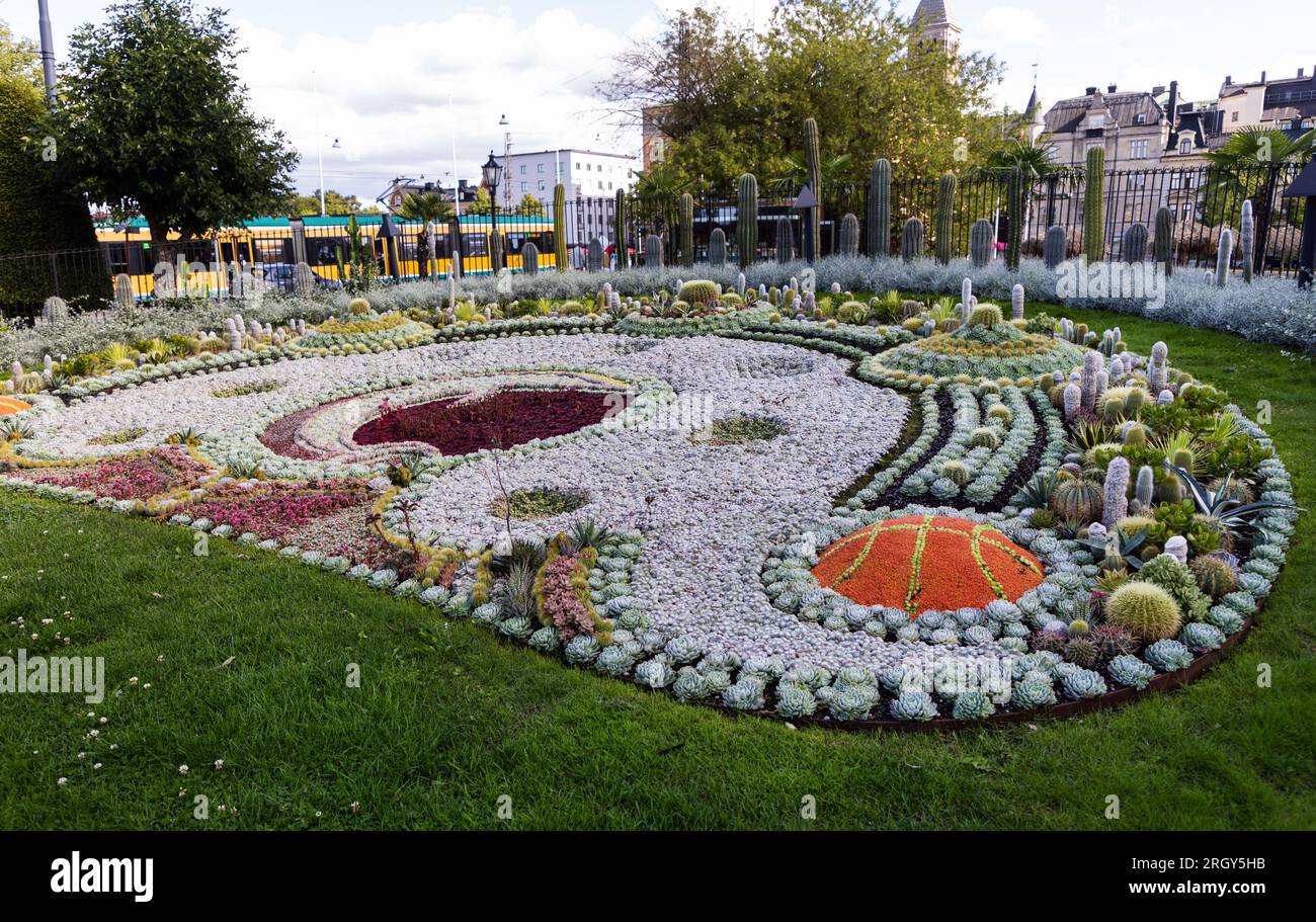 Il cactus piantato nel parco Karl Johans nel centro di Norrköping, Svezia. Il tema di quest'anno celebra il 60° anniversario del club di basket Norrköping Dolphins. Un tram sullo sfondo. Foto Stock