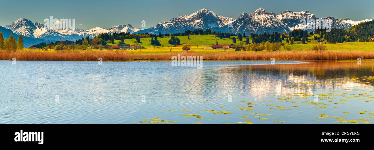 vista panoramica sul paesaggio rurale con catena montuosa e lago in autunno Foto Stock