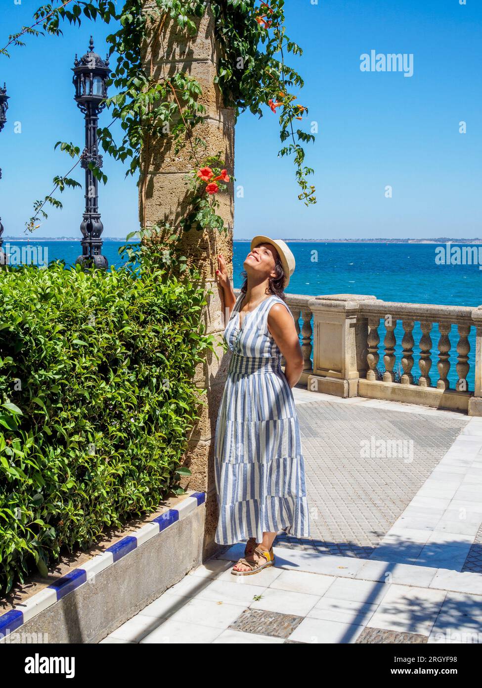 Una turista caucasica che si gode un bagno di sole mentre posa nei giardini Clara Campoamor. Cadice, Andalusia, Spagna. Foto Stock