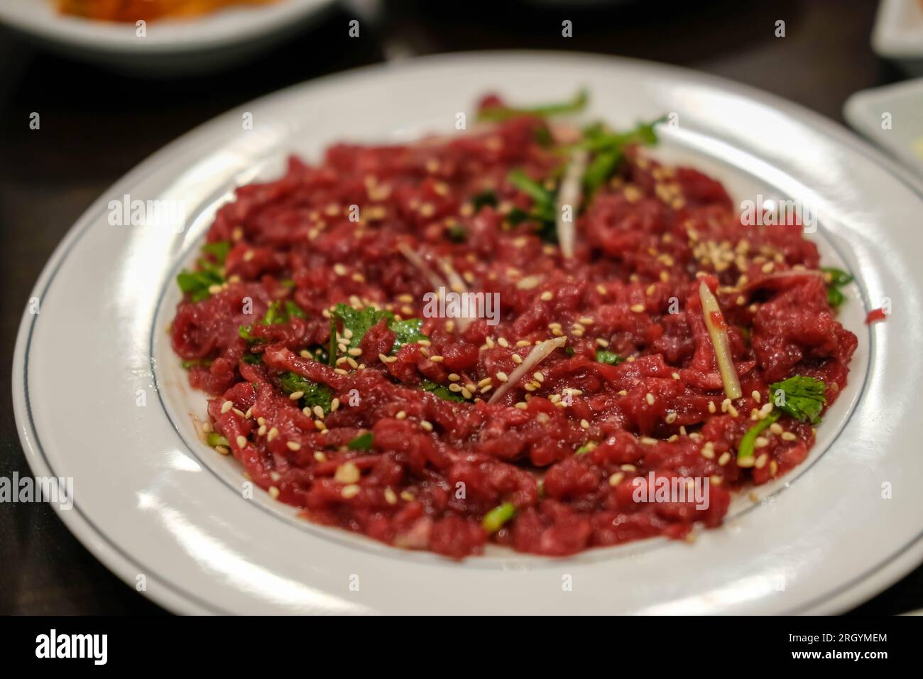 Yukhoe, carne cruda di manzo tagliata a fette e condita con sale, zucchero, olio di sesamo, pepe e aglio, ecc.. E' famoso cibo coreano. Foto Stock