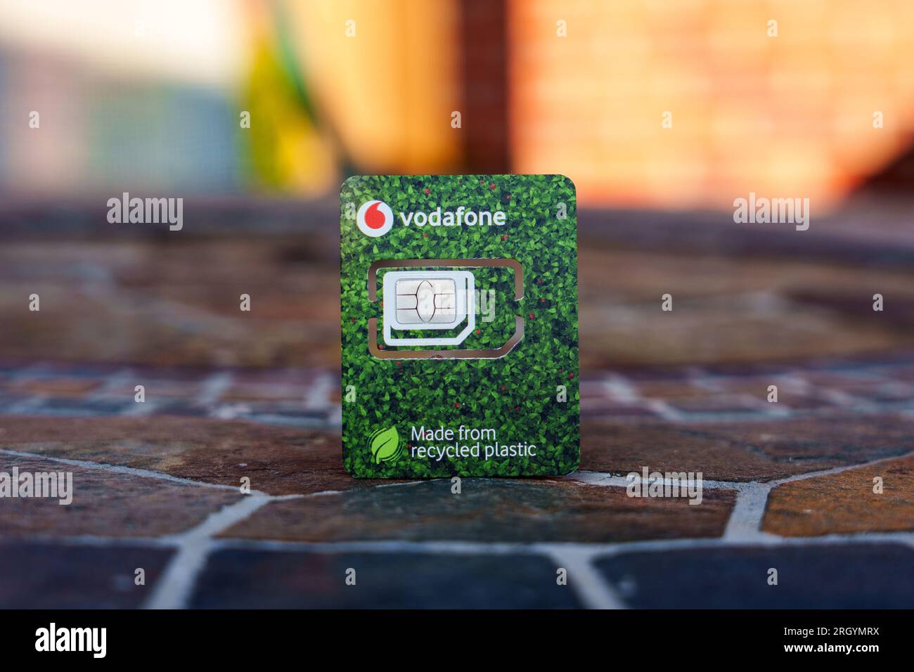 Scheda SIM Vodafone realizzata in plastica riciclata. Immagine ravvicinata con sfondo sfocato e spazio di copia. Stafford, Regno Unito, 12 agosto 2023 Foto Stock
