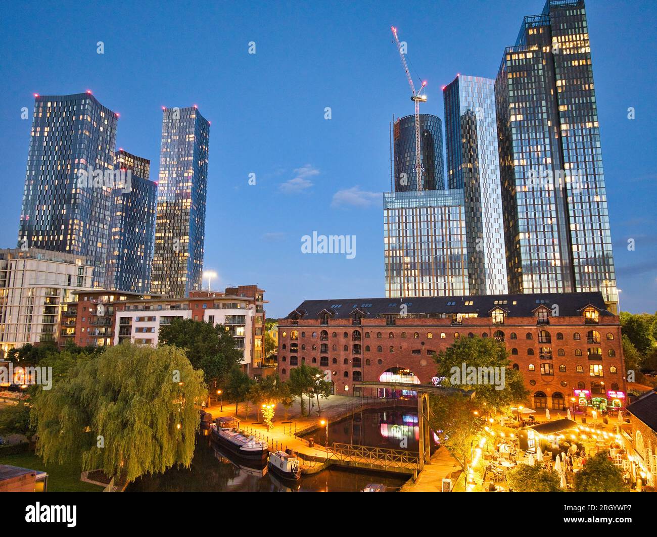 Foto aerea dei grattacieli di Manchester e del nuovo sviluppo preso da Castlefield, che mostra il vivace skyline in continua evoluzione all'ora blu Foto Stock