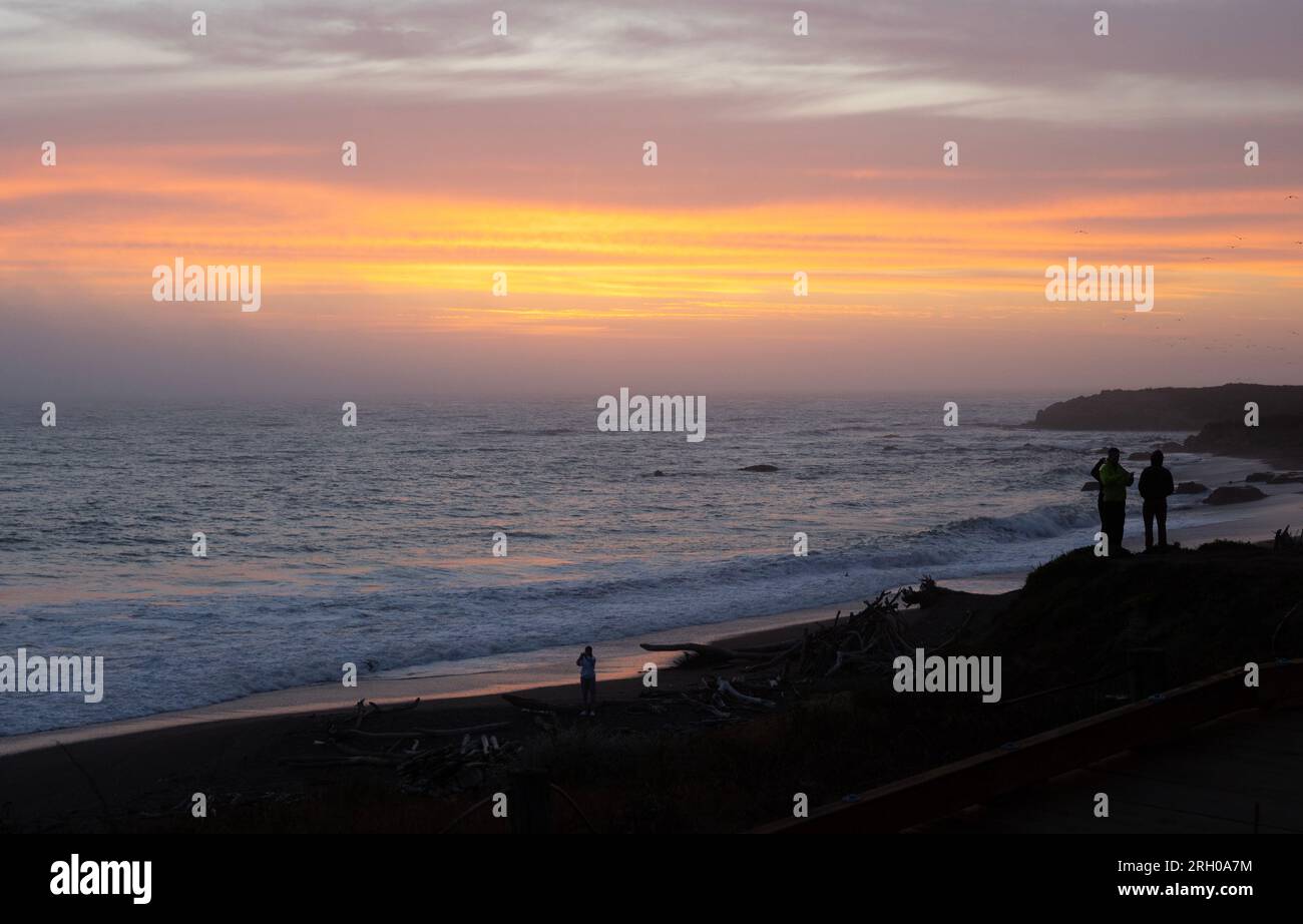 Gente che guarda il tramonto sulla spiaggia di Moonstone Foto Stock