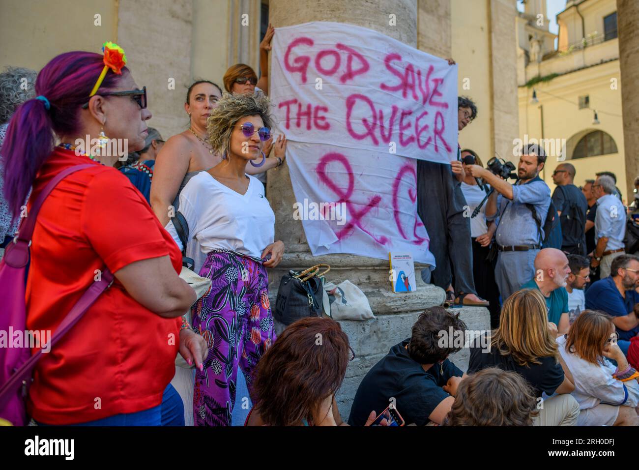 Roma, Roma, Italia. 12 agosto 2023. Alcune attiviste femministe mostrano lo striscione con le parole "Good Save the Queer" e il libro scritto da Michela Murgia in attesa del corpo in occasione dei funerali dello scrittore a Roma. Michela Murgia, morta all'età di 51 anni dalla sua famiglia queer di dieci persone e dai suoi quattro figli "anima", surroundedÂ scrittrice, blogger, drammaturga e attivista politica, soprattutto nel campo della parità di genere e dell'antifascismo. Crediti: ZUMA Press, Inc./Alamy Live News Foto Stock