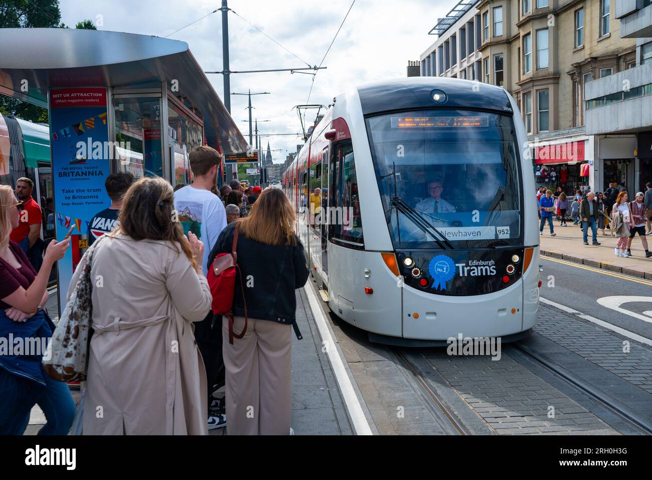 Il pubblico aspetta di salire a bordo del tram su Princes Street a Edimburgo, Scozia, Regno Unito Foto Stock
