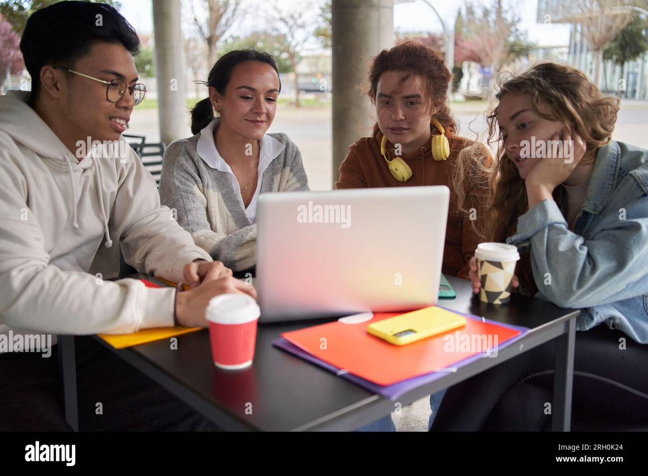 Gruppo di studenti che condividono un laptop per fare i compiti Foto Stock