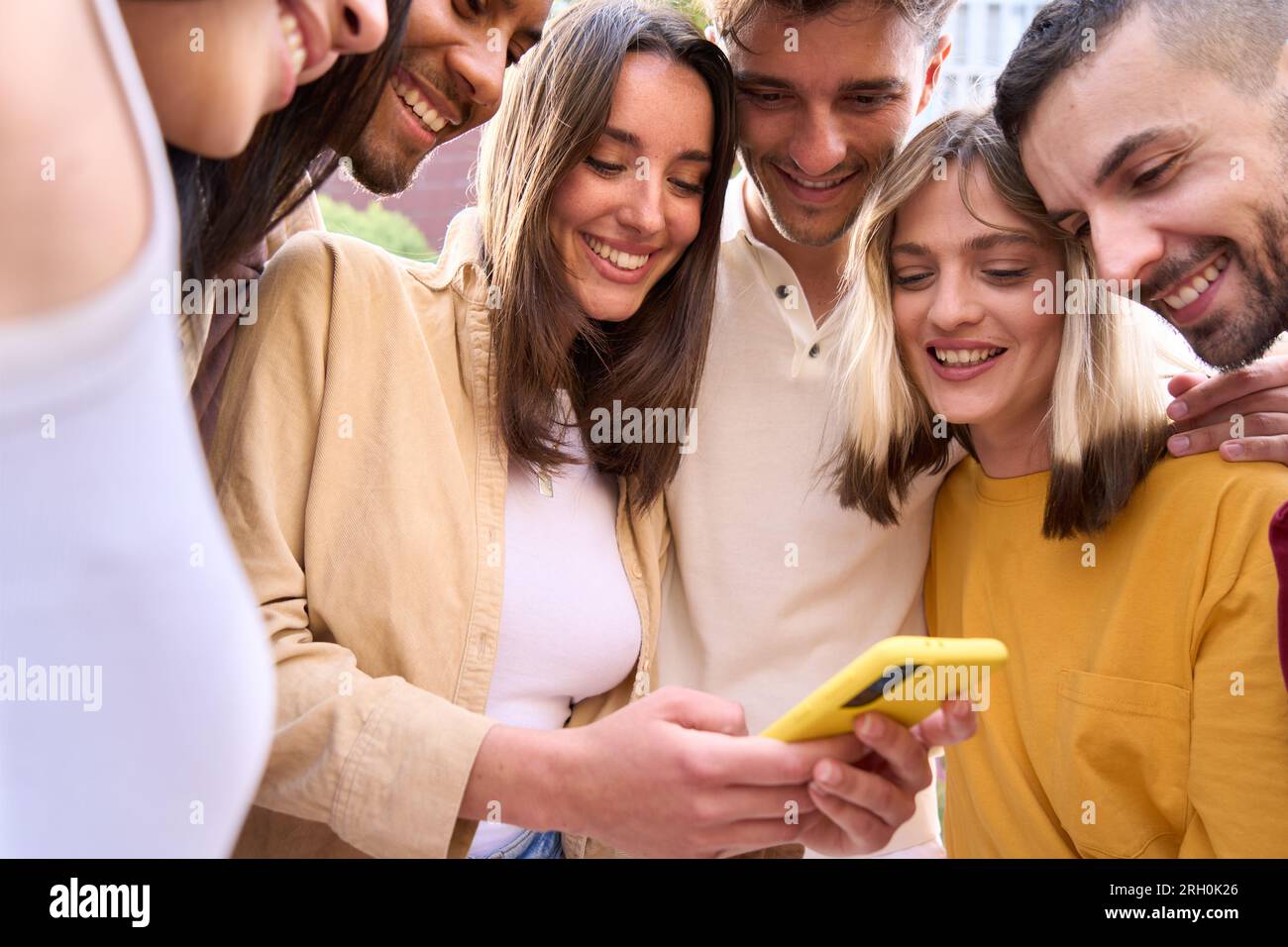 Gruppo giovane di gente gen z che si diverte usando il cellulare insieme fuori.felice comunità di studenti Foto Stock