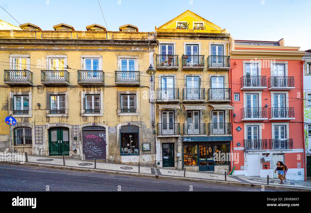 Edifici storici colorati con balconi in ferro sulla ripida strada Calcada do Combro, architettura tradizionale del quartiere di Lisbona in Portogallo Foto Stock
