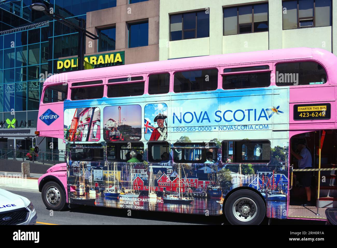 Halifax, Canada - 2 agosto 2023: Un autobus rosa della Gary Line con foto che pubblicizzano la nuova Scozia, compresa la pittoresca città di Lunenburg, guida su S. Foto Stock