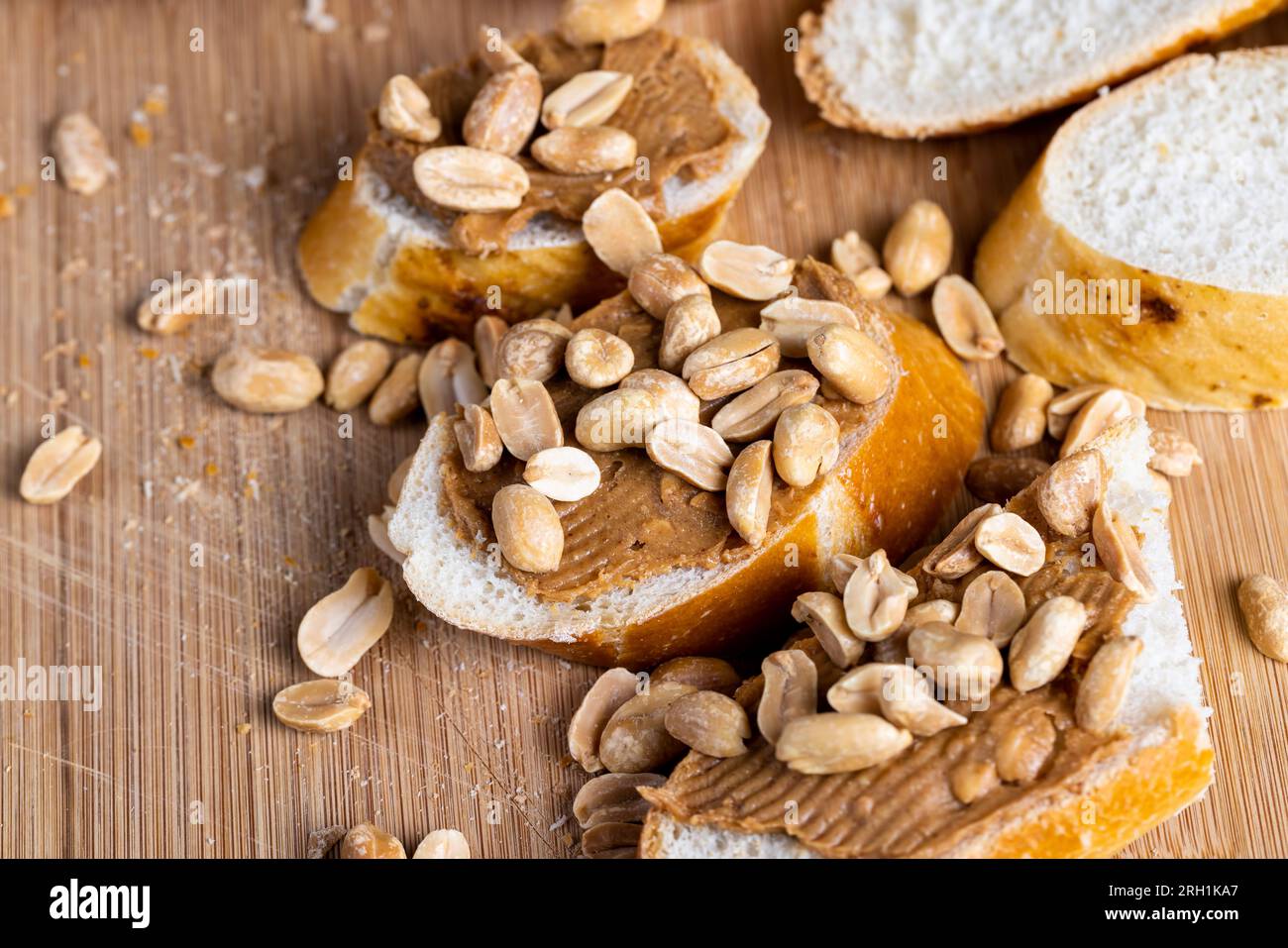 baguette di grano fresco e pasta di arachidi, facendo colazione di pane e burro di arachidi con pezzi di arachidi Foto Stock