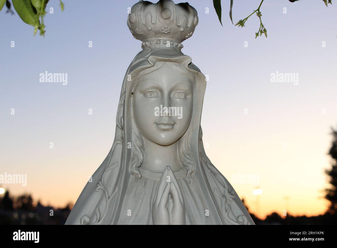 "Divina Serenità - Un'accattivante statua in marmo di una donna in preghiera, che evoca un profondo senso di pace e di contemplazione spirituale." Foto Stock