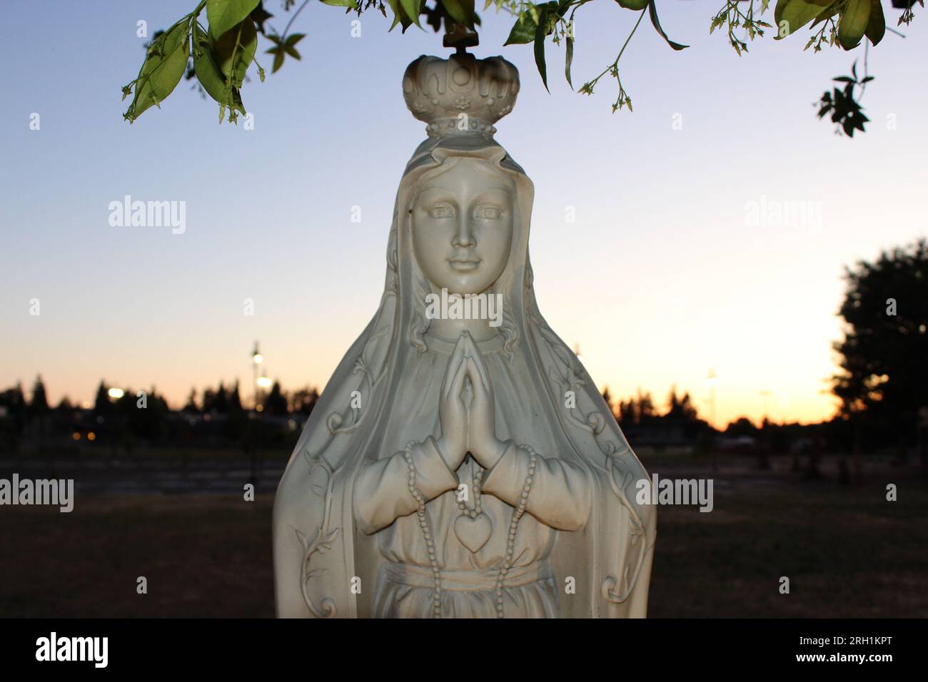 "Divina Serenità - Un'accattivante statua in marmo di una donna in preghiera, che evoca un profondo senso di pace e di contemplazione spirituale." Foto Stock