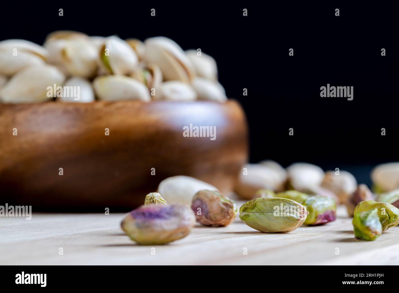 pistacchio verde fritto in una conchiglia, un mazzo di deliziosi e sani pistacchi sul tavolo e sulla tavola Foto Stock