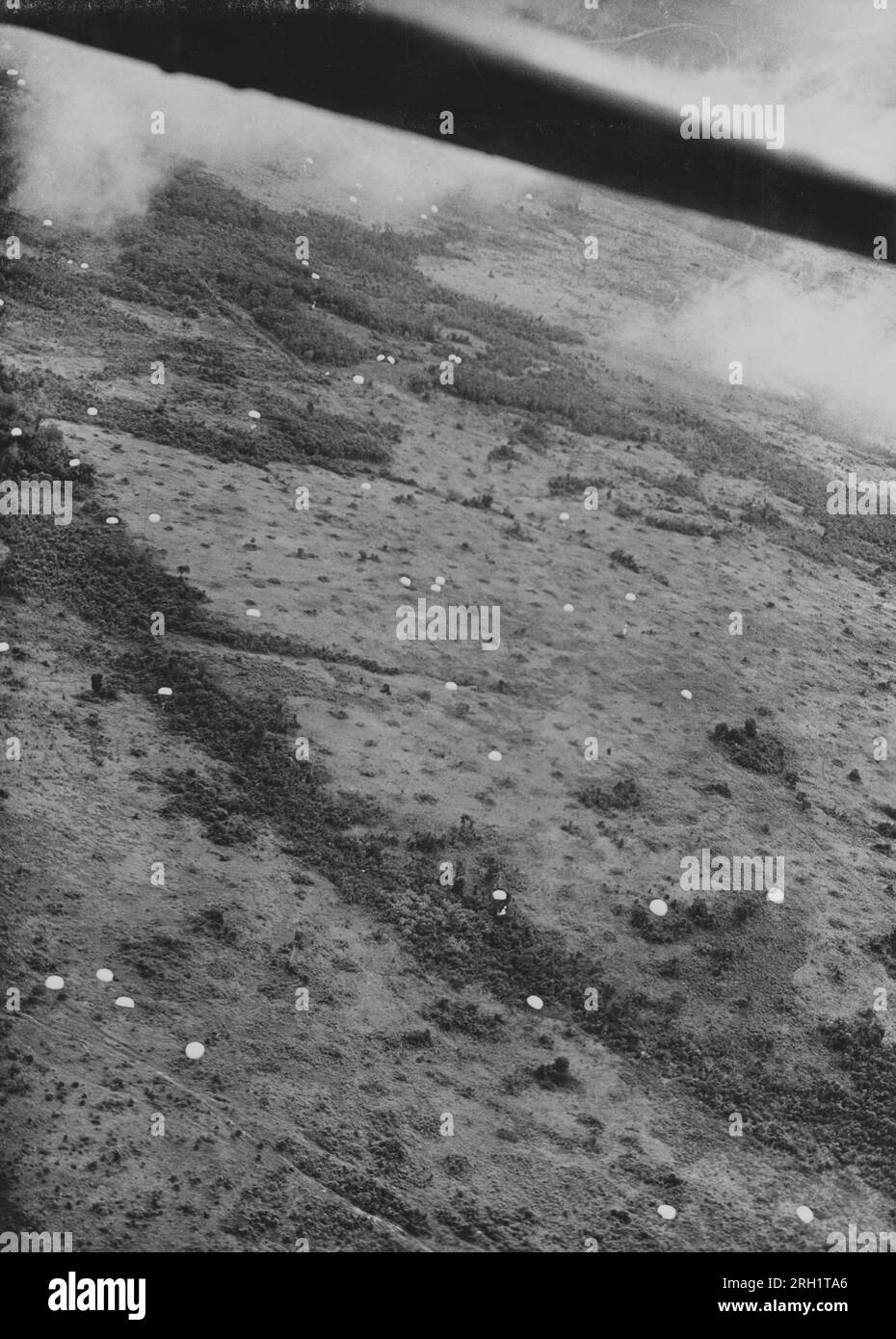 Battaglia di Palembang, febbraio 13-15 1942. Dal punto di vista di un aereo dell'esercito imperiale giapponese, i cieli sopra Palembang, Sumatra sono pieni di paracadute del «Teishin Shudan» (gruppo di predoni) mentre compiono il loro audace raid sulla città ricca di petrolio, il 14 febbraio 1942. Le truppe aviotrasportate del Teishin Shudan avrebbero combattuto con la guarnigione del KNIL e avrebbero catturato con successo i giacimenti petroliferi e le raffinerie della zona entro il giorno seguente. Foto Stock