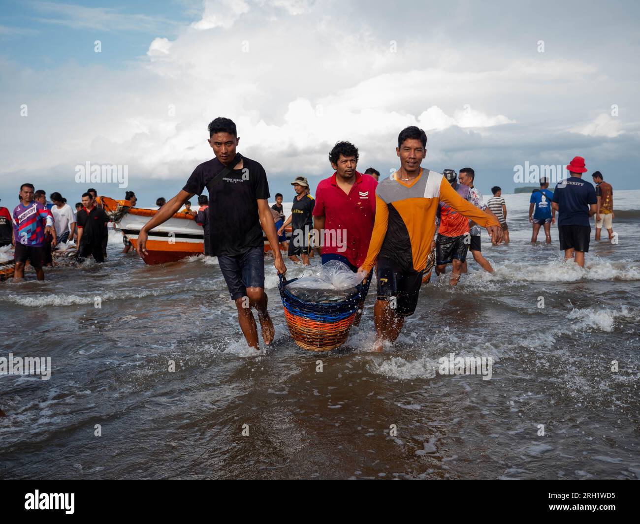 La comunità costiera di Pasir Jambak, Padang, stava aspettando e trasportando cesti di catture di pescatori giovedì (10/8/2023). Foto Stock