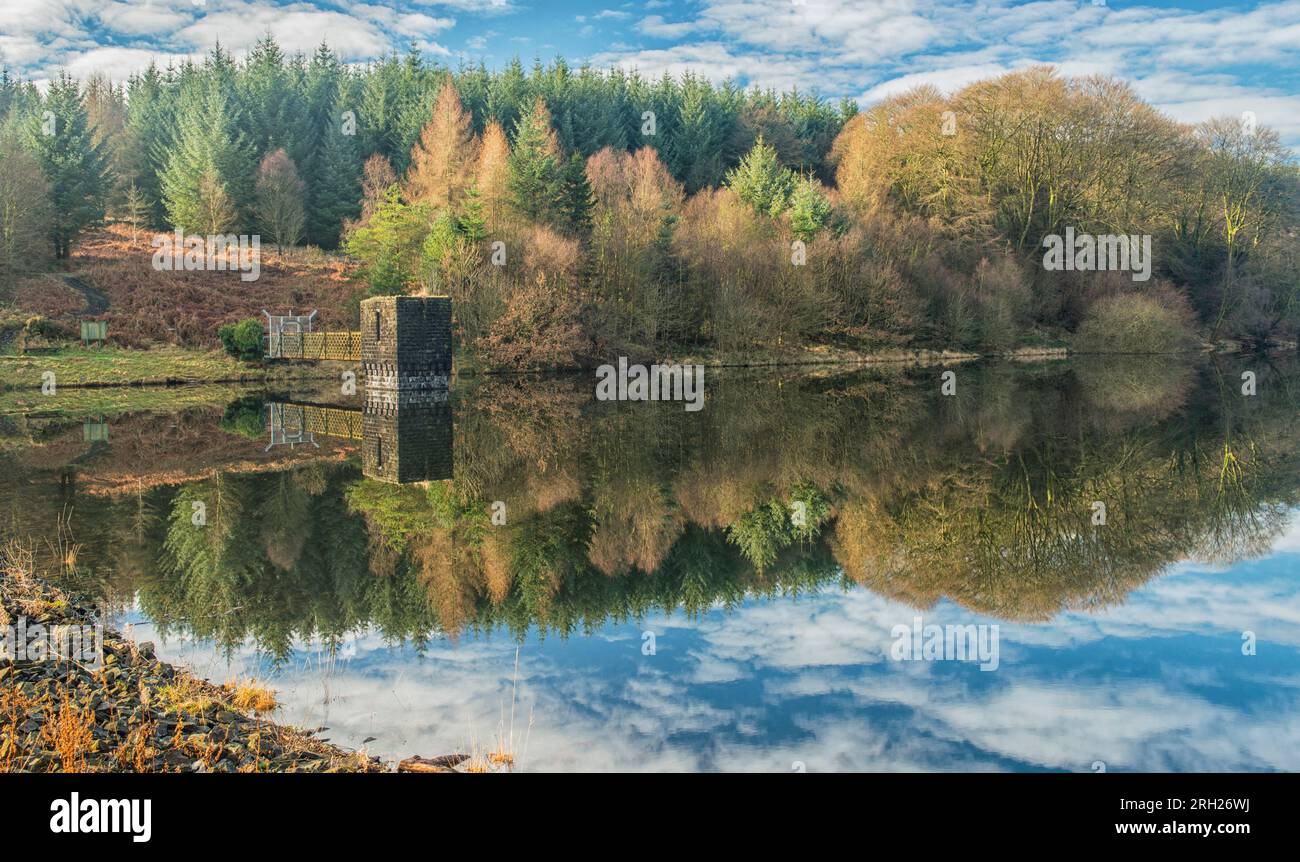 Il lago artificiale di Llanwonno, nel profondo della foresta di Llanwonno, vicino alla valle di Rhondda Fach, nel Galles del Sud, con splendidi riflessi di alberi e nuvole Foto Stock