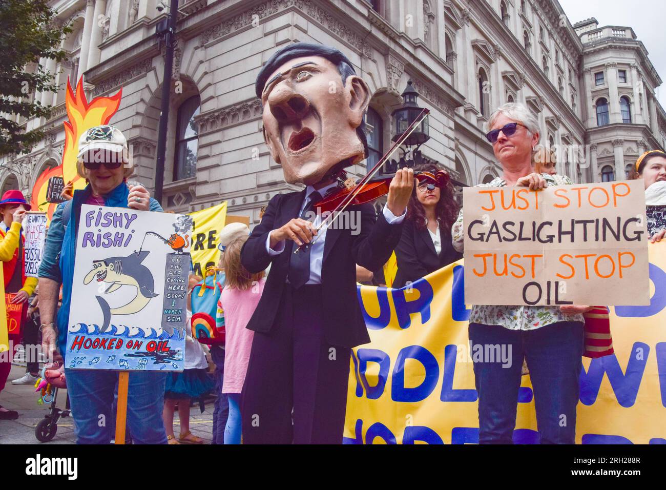 Londra, Regno Unito. 3 agosto 2023. Un manifestante vestito da Rishi Sunak suona il violino mentre i manifestanti del clima si riuniscono fuori Downing Street in risposta al governo del Regno Unito che ha rilasciato 100 nuove licenze per petrolio e gas. Foto Stock