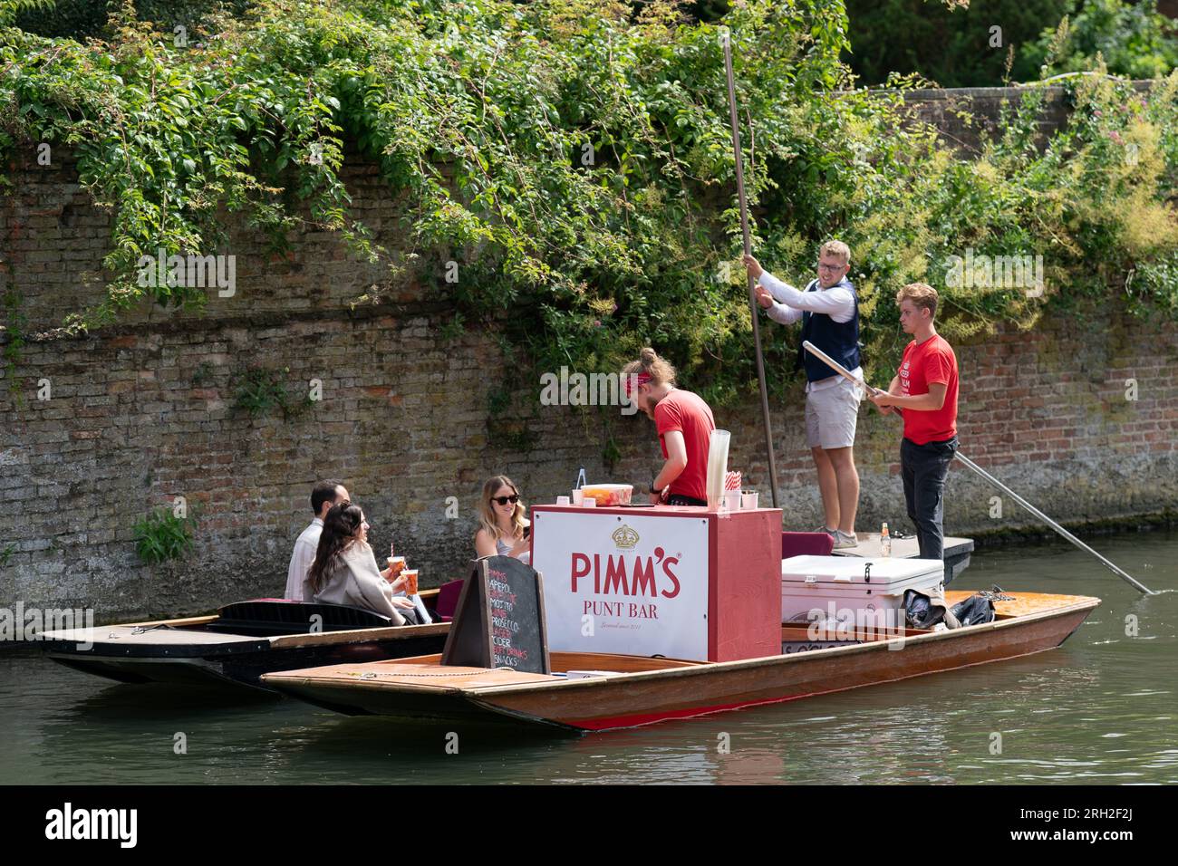 Un bar Pimm's su un punt serve bevande ai turisti che fanno un giro sul fiume Cam a Cambridge. Secondo il Met Office, le temperature potrebbero raggiungere i 30 °C in alcune parti del Regno Unito la prossima settimana, dopo che le forti piogge bagnano il paese. Data foto: Domenica 13 agosto 2023. Foto Stock