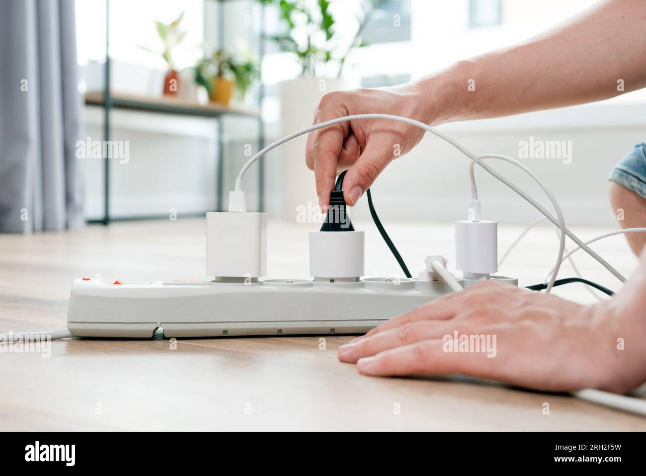 Spina elettrica nella presa di corrente a casa. Concetto di efficienza energetica Foto Stock