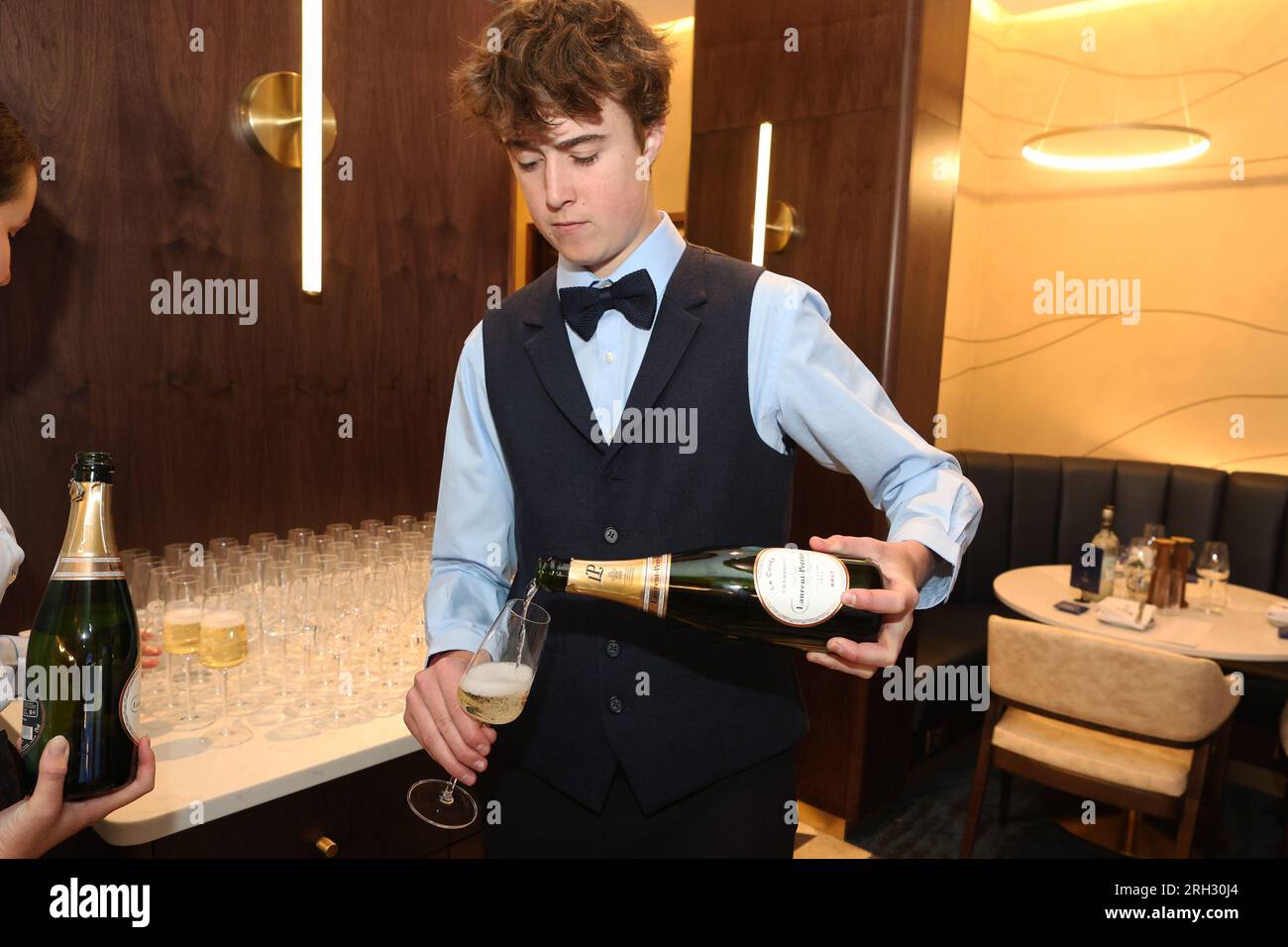 Un cameriere che versa champagne Foto Stock