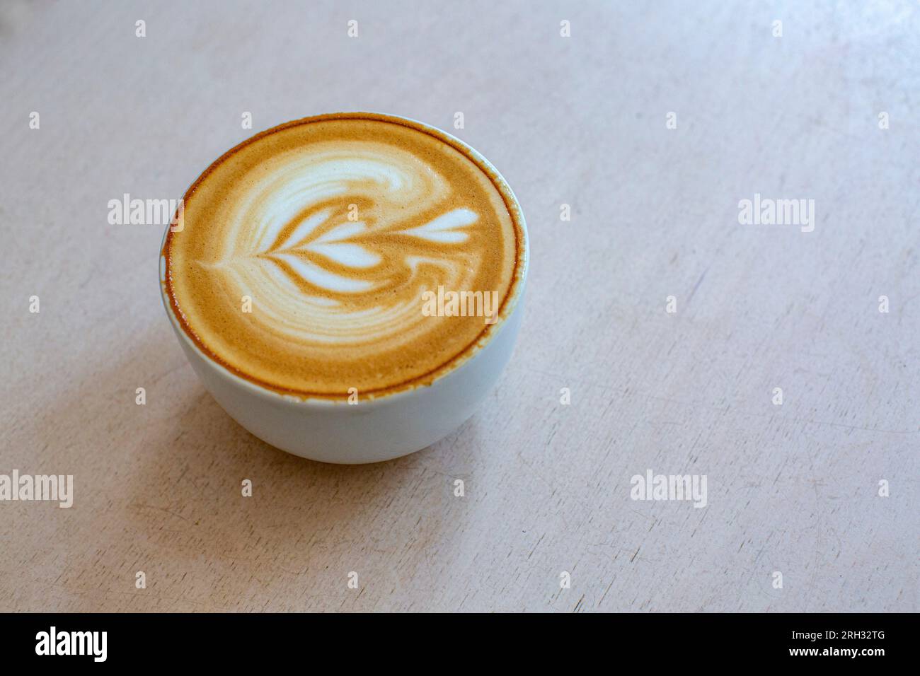 Un caffè bianco piatto perfetto servito in una tazza stile tulipano Foto Stock