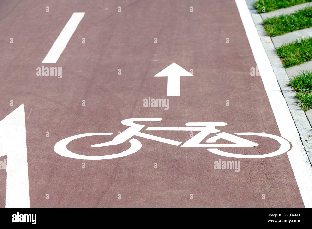 Designazione di bicicletta e freccia sulla strada, percorso pedonale in una città Foto Stock
