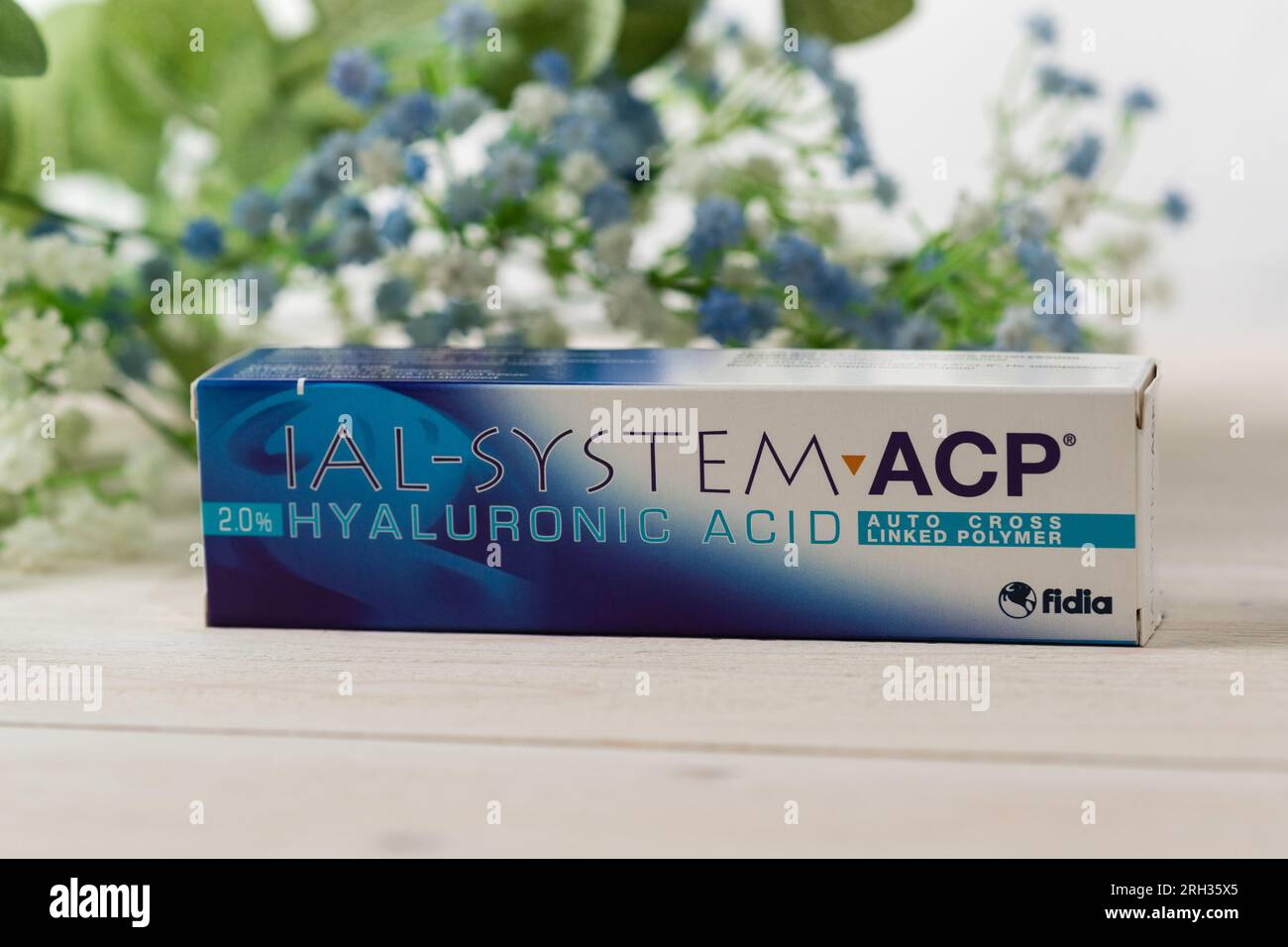 Russia, Krasnodar - 22 novembre 2022: Una scatola di preparazione cosmetica IAL-System ACP si erge su un tavolo di legno bianco con fiori blu Foto Stock