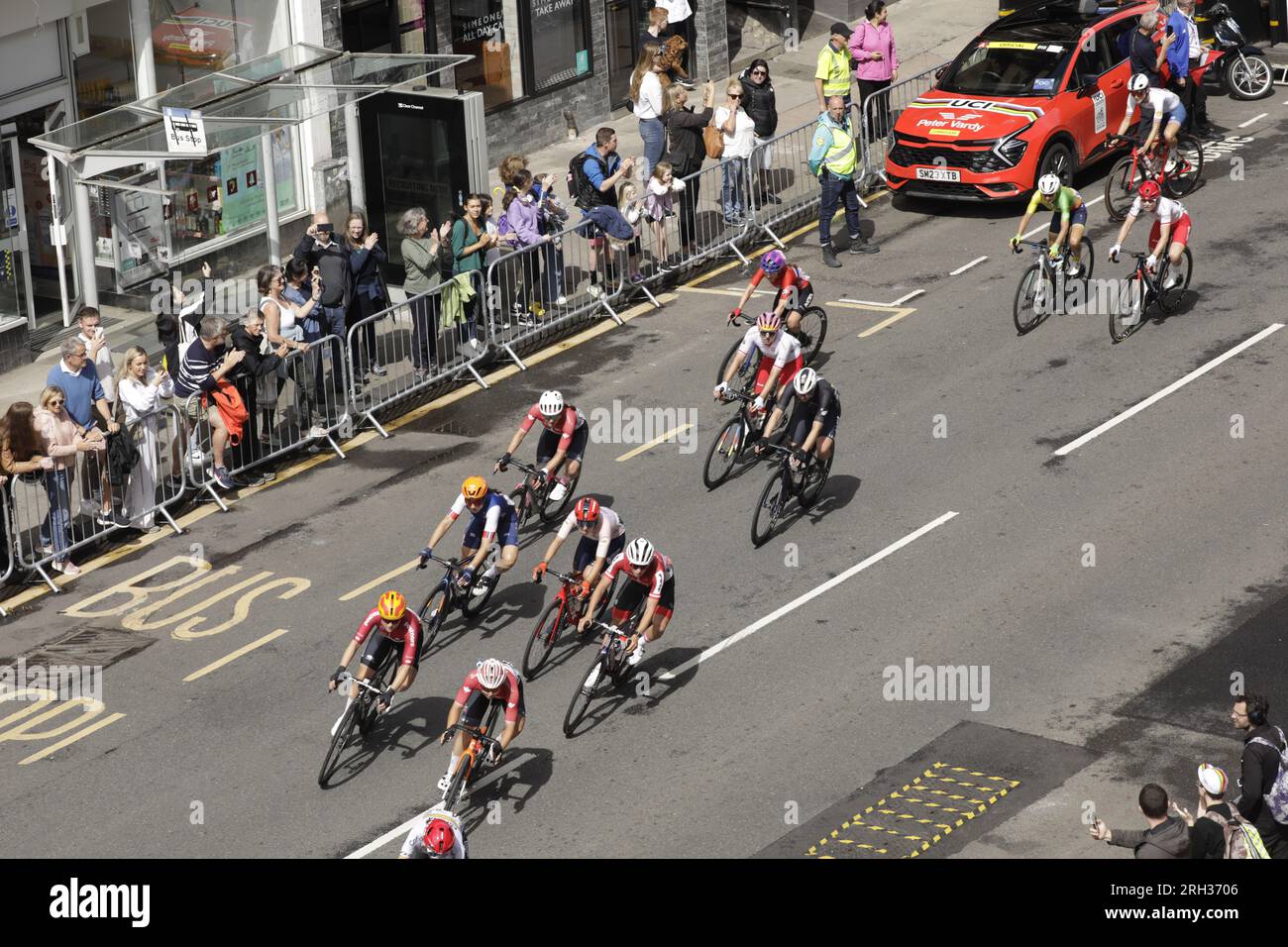 Glasgow, Scozia, Regno Unito. 13 agosto 2023. Vista elevata di un gruppo internazionale di ciclisti professionisti che gareggiano nella UCI Cycling World Championships Women Elite Road Race 2023, che ha iniziato a Loch Lomond e si è conclusa con sei giri di strade cittadine di Glasgow. Crediti: Elizabeth Leyden/Alamy Live News Foto Stock