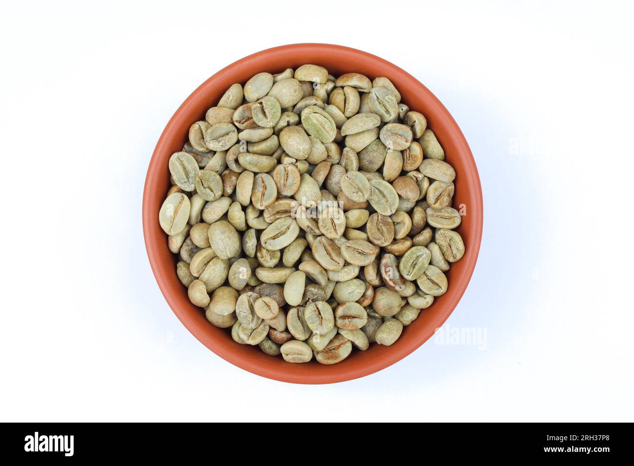 Chicchi di caffè verdi in una ciotola su sfondo bianco vista ravvicinata Foto Stock